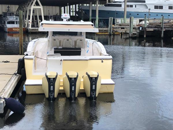 2019 Altima 38 Xcape boat docked with triple outboard engines.