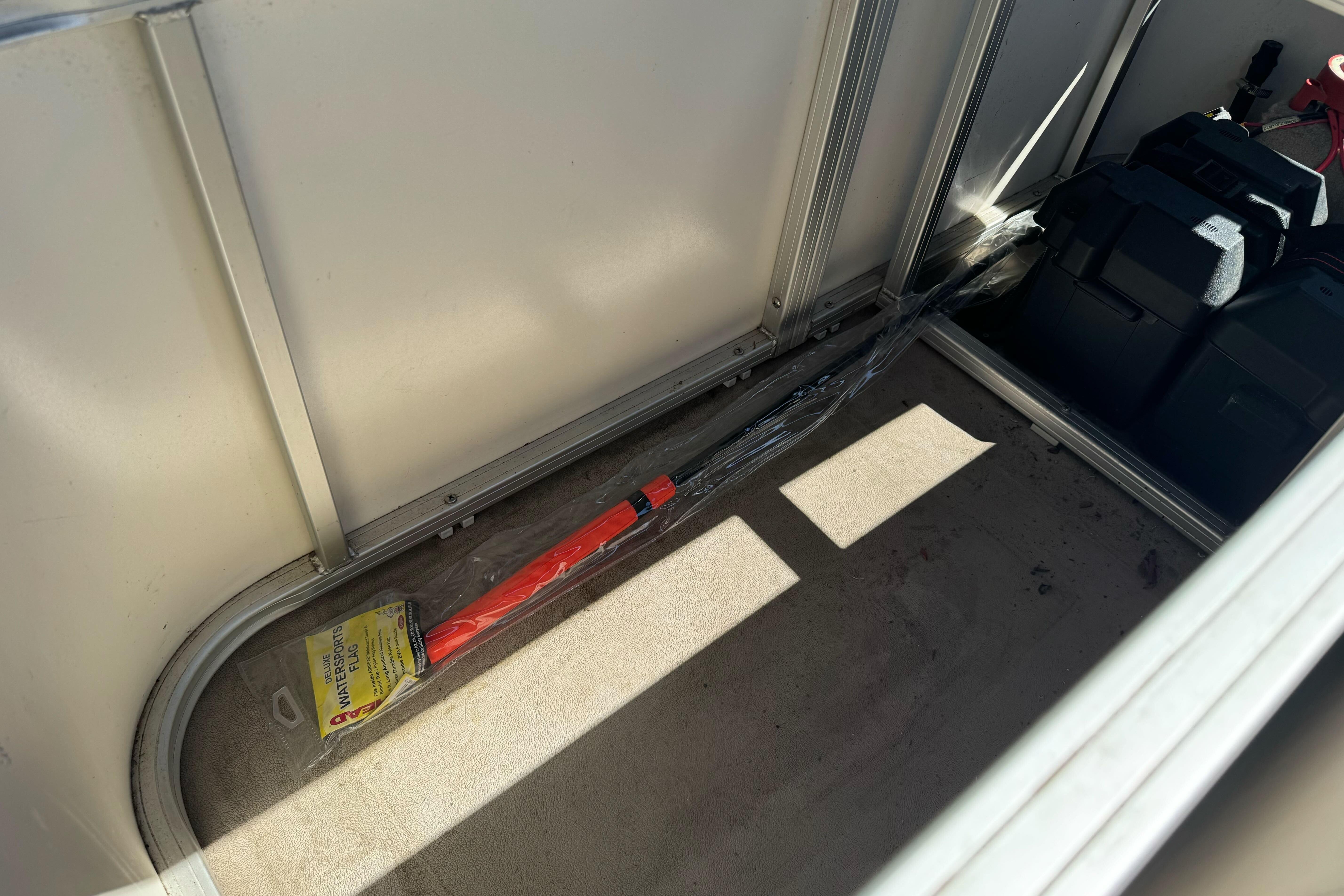 Interior of a 2011 Sun Tracker Party Barge 21 with storage compartment and equipment.