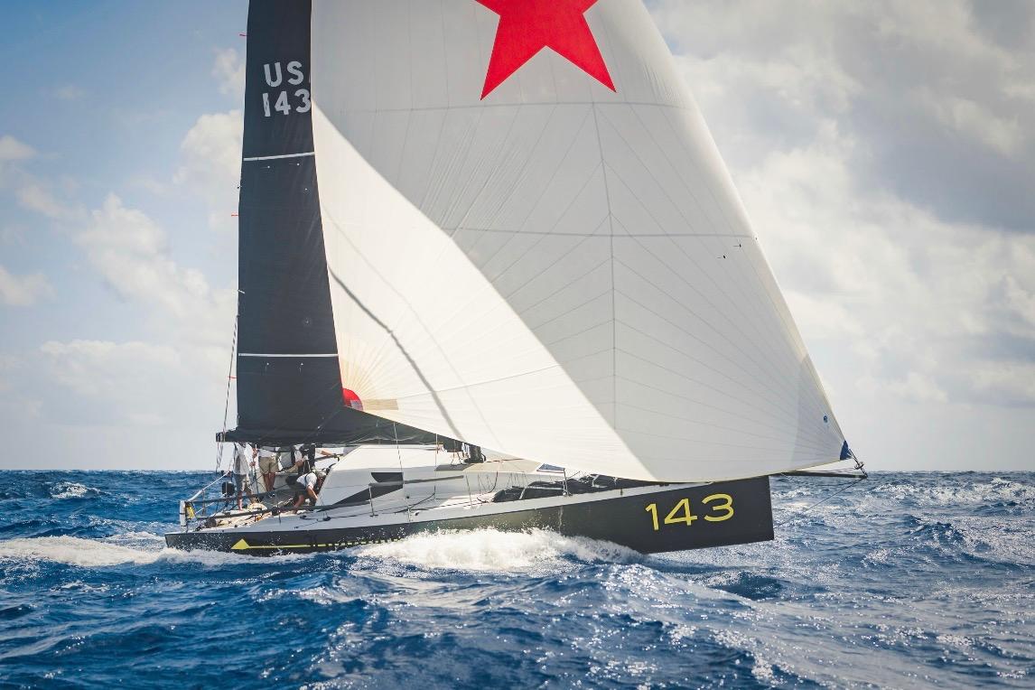 Sailing yacht Class 40 Owen Clarke Design 2015 navigating ocean waves under clear skies.