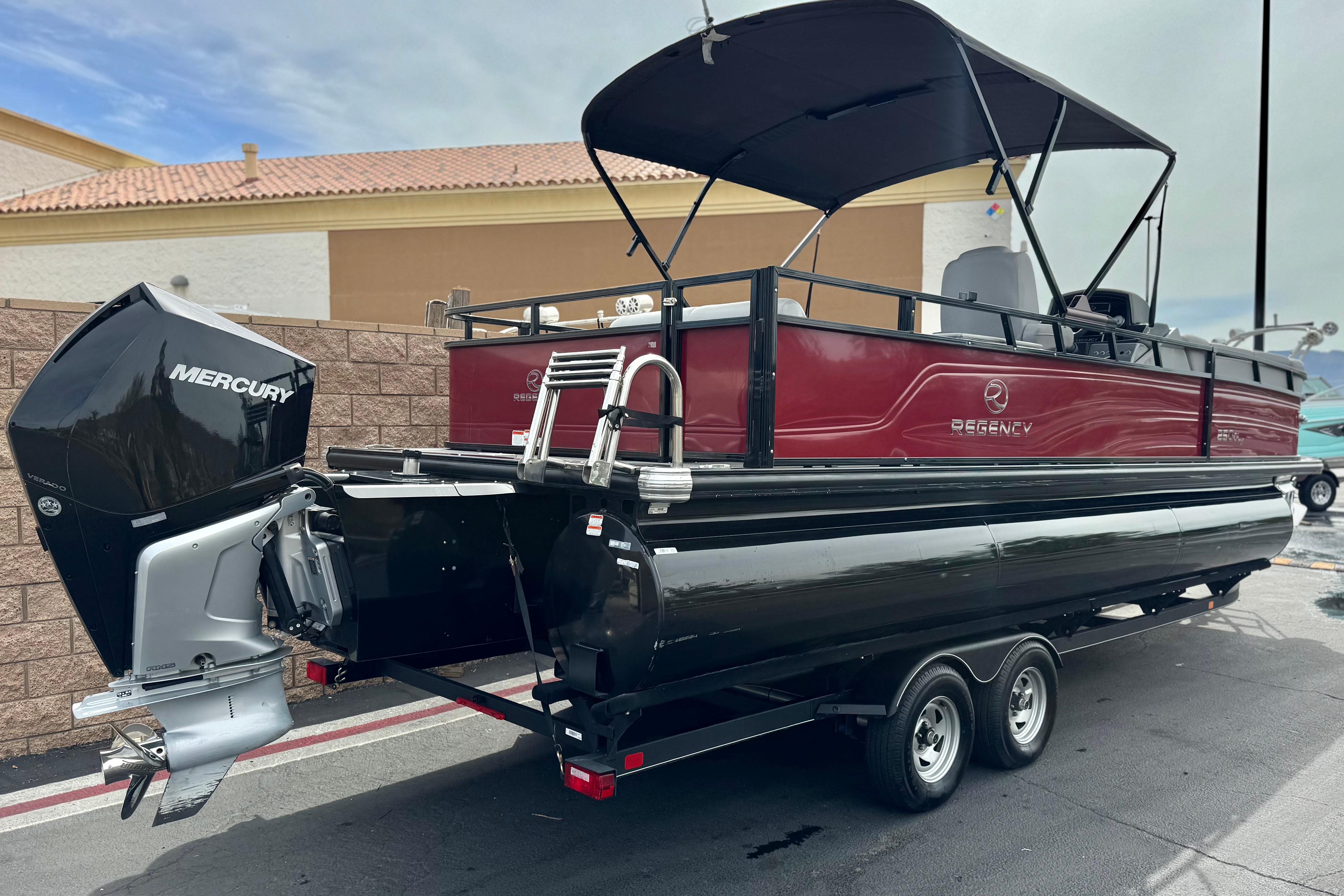 2022 Regency 250 DL3 pontoon boat with Mercury outboard engine on trailer.