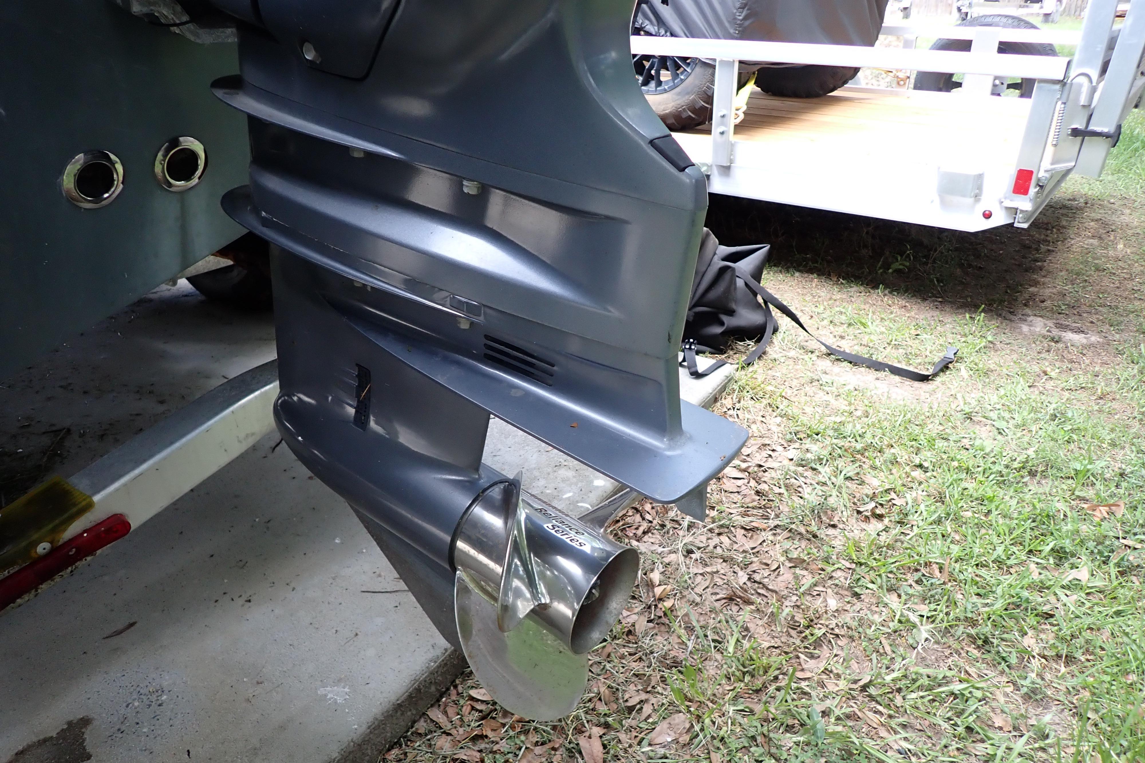 2019 Key West 263 FS boat motor and propeller on trailer, parked on grass.