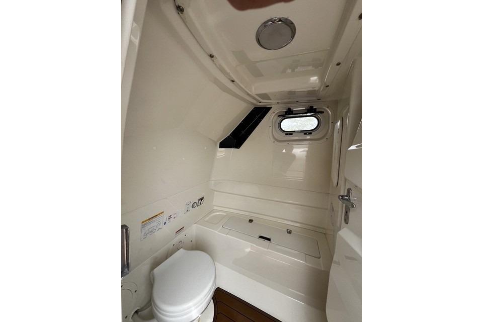 Interior cabin of 2022 Brig Eagle 8 boat with toilet and porthole window.