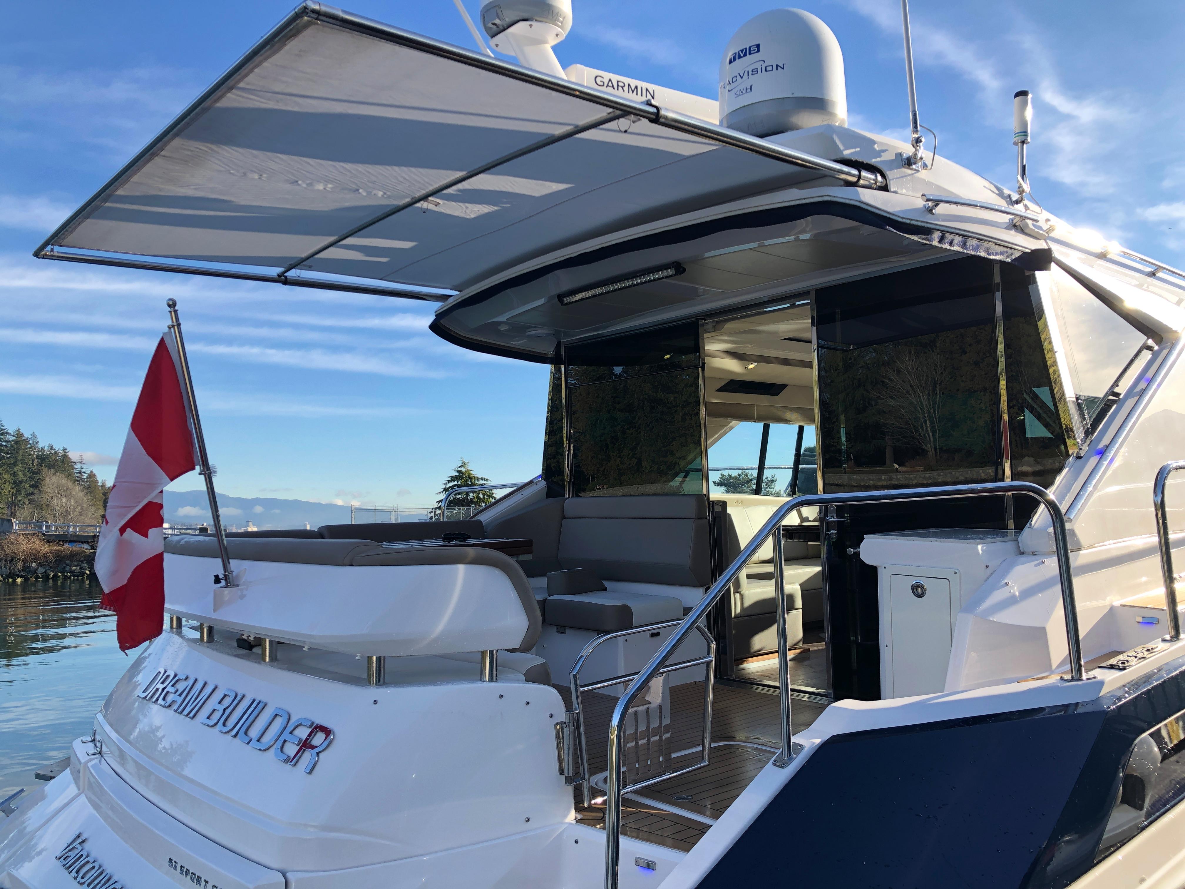 2017 Regal 53 Sport Coupe yacht with open deck, Canadian flag, and scenic water view.