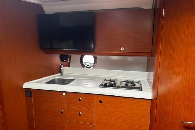 Interior of 2013 Beneteau Gran Turismo 38 yacht with kitchenette and porthole window.