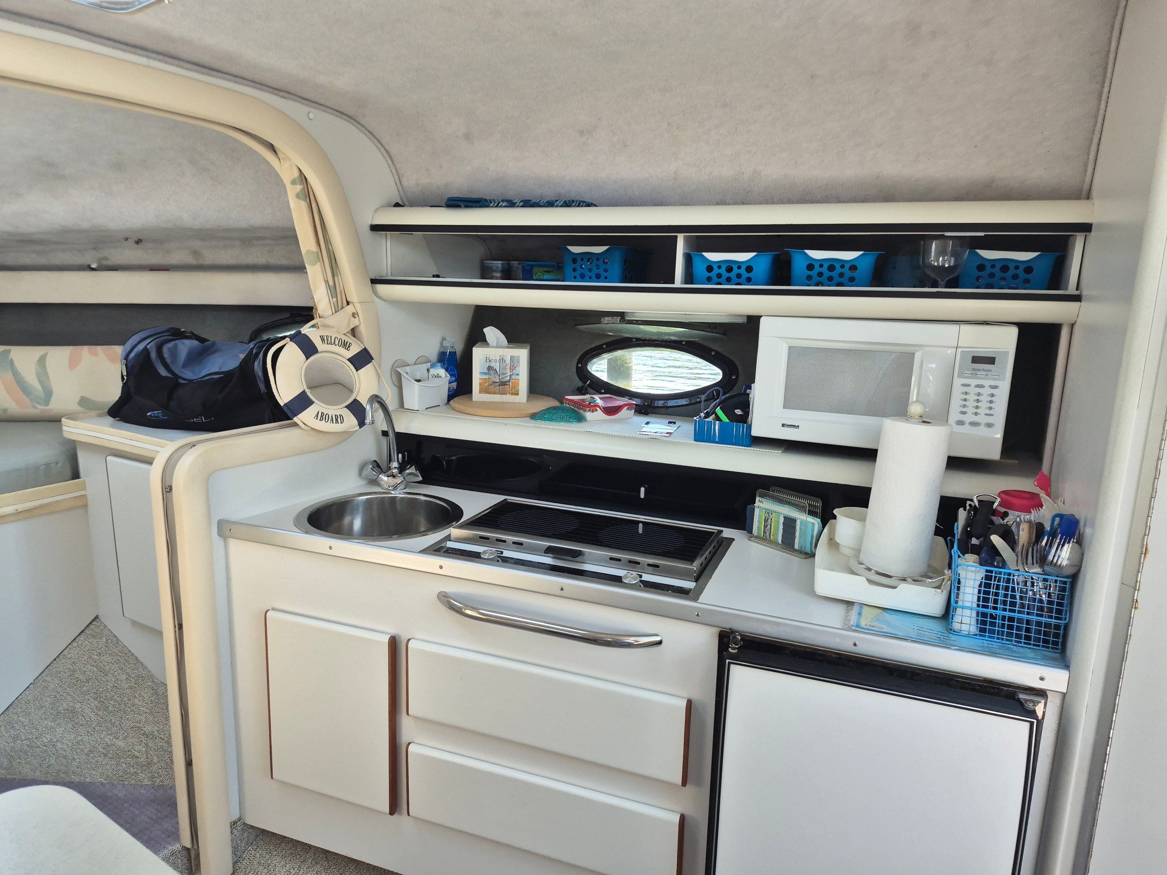 Interior of a 1989 Tiara Yachts Slickcraft with kitchen, sink, stove, and microwave.