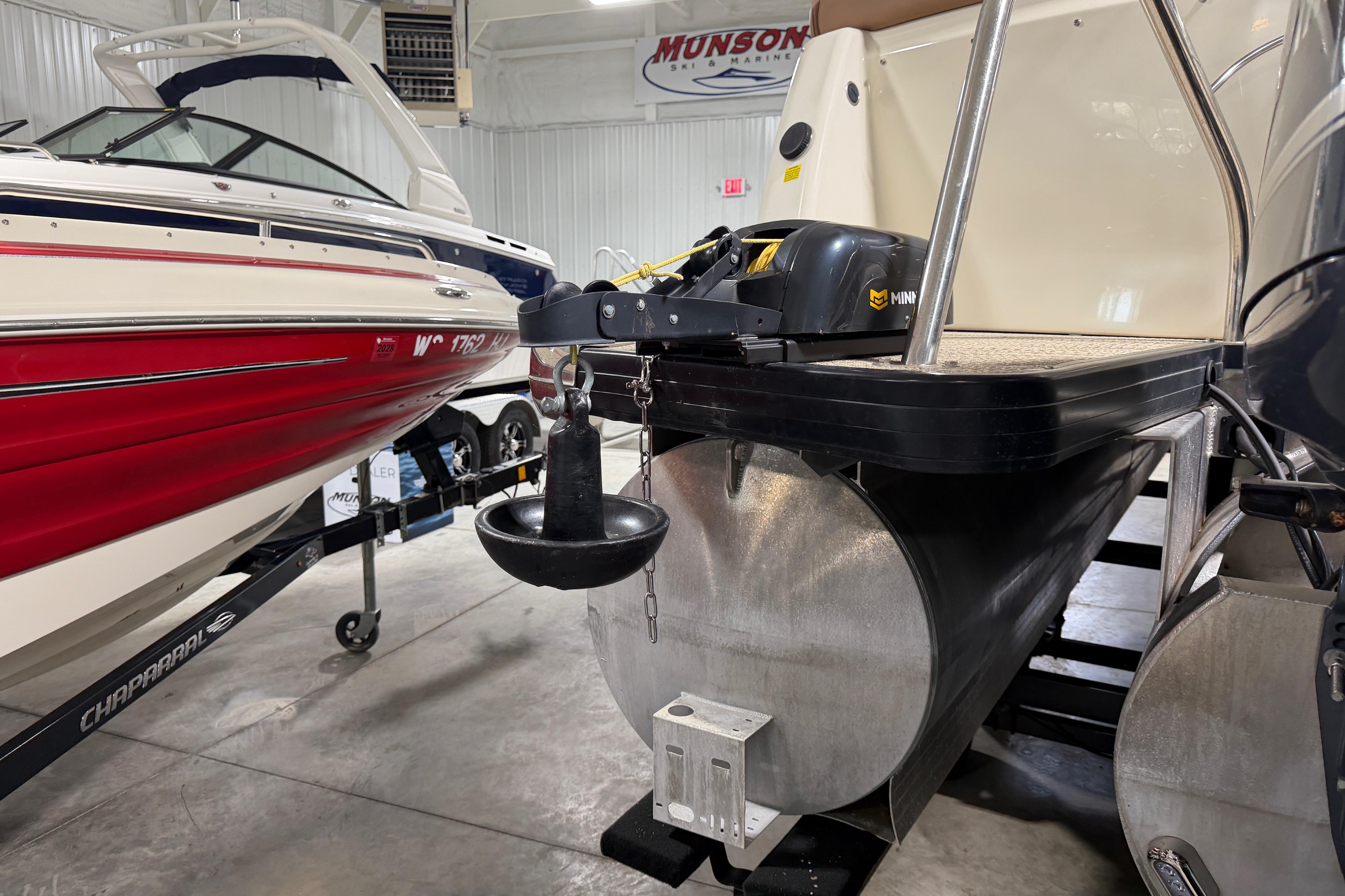 2018 Godfrey Sanpan 2500 ULC pontoon boat in showroom, alongside a red Chaparral boat.