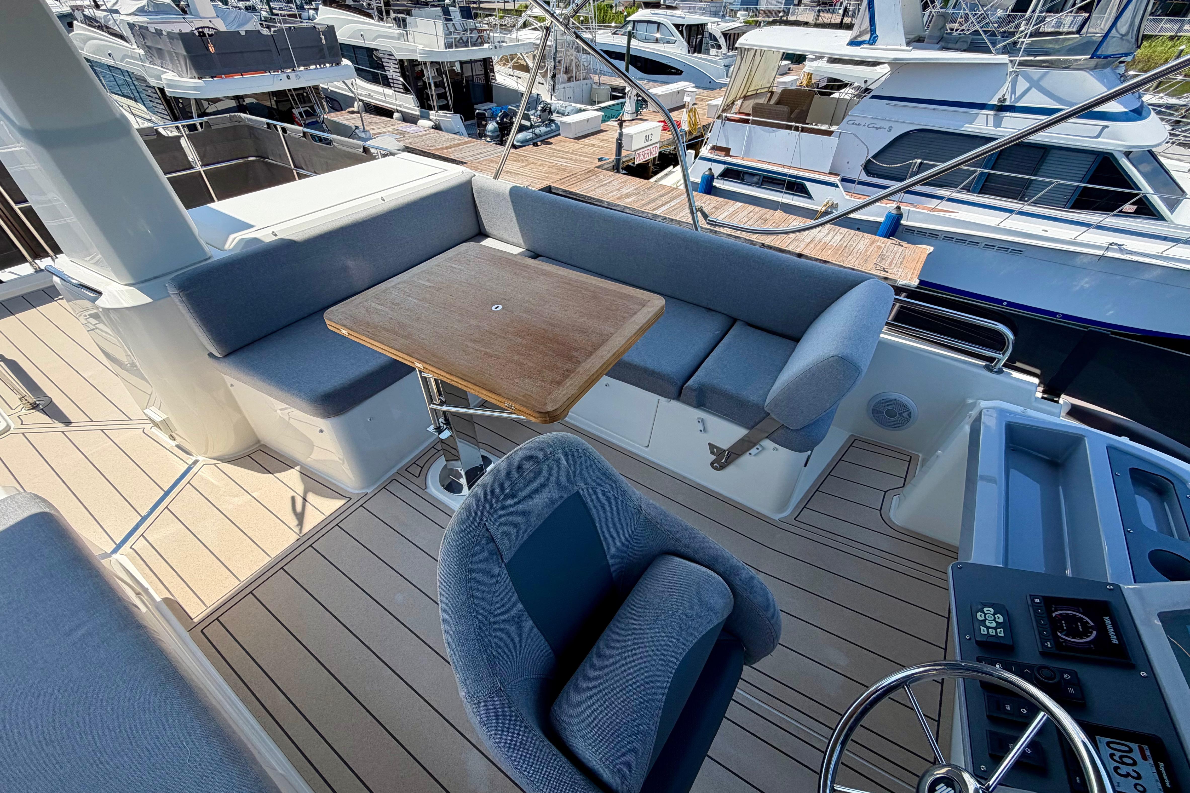 Flybridge of 2025 Beneteau Swift Trawler 41 Fly with seating and table, docked at marina.
