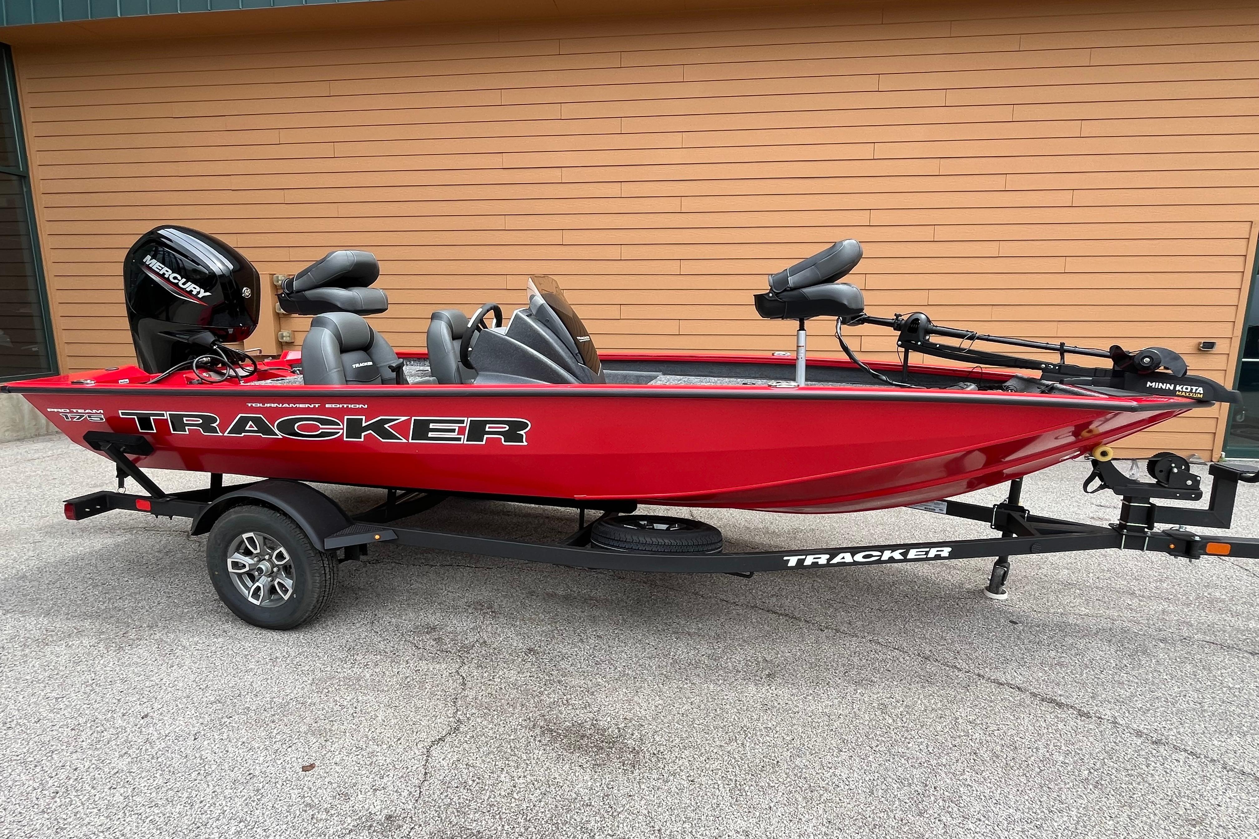 2026 Tracker Pro Team 175 boat, red, on trailer, with Mercury engine, parked outdoors.