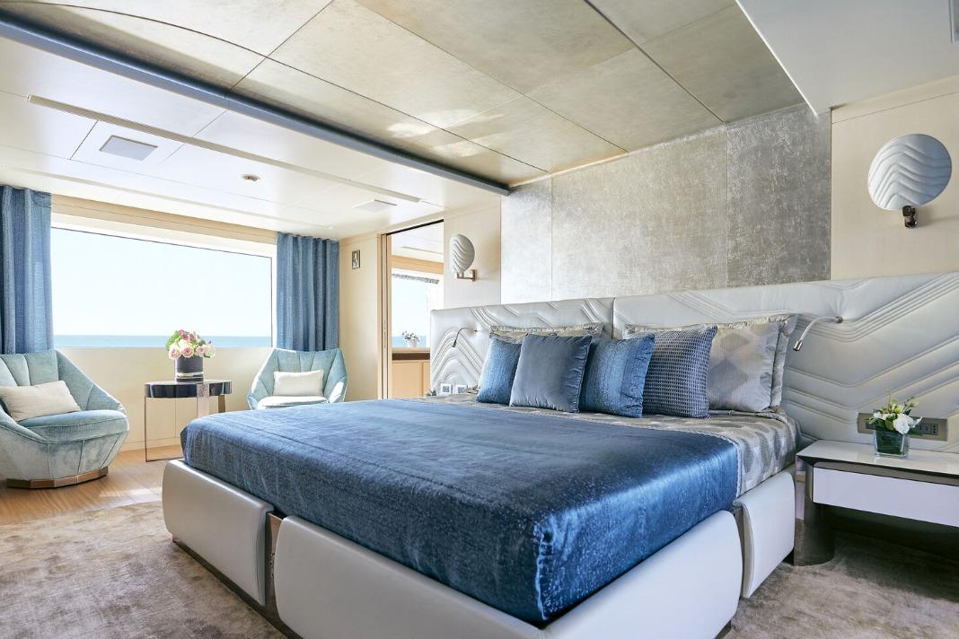 Luxurious bedroom interior on 2021 Benetti B.NOW 50M yacht with elegant blue decor.