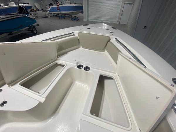 2024 Key West 219 FS boat with open storage compartments and cup holders.