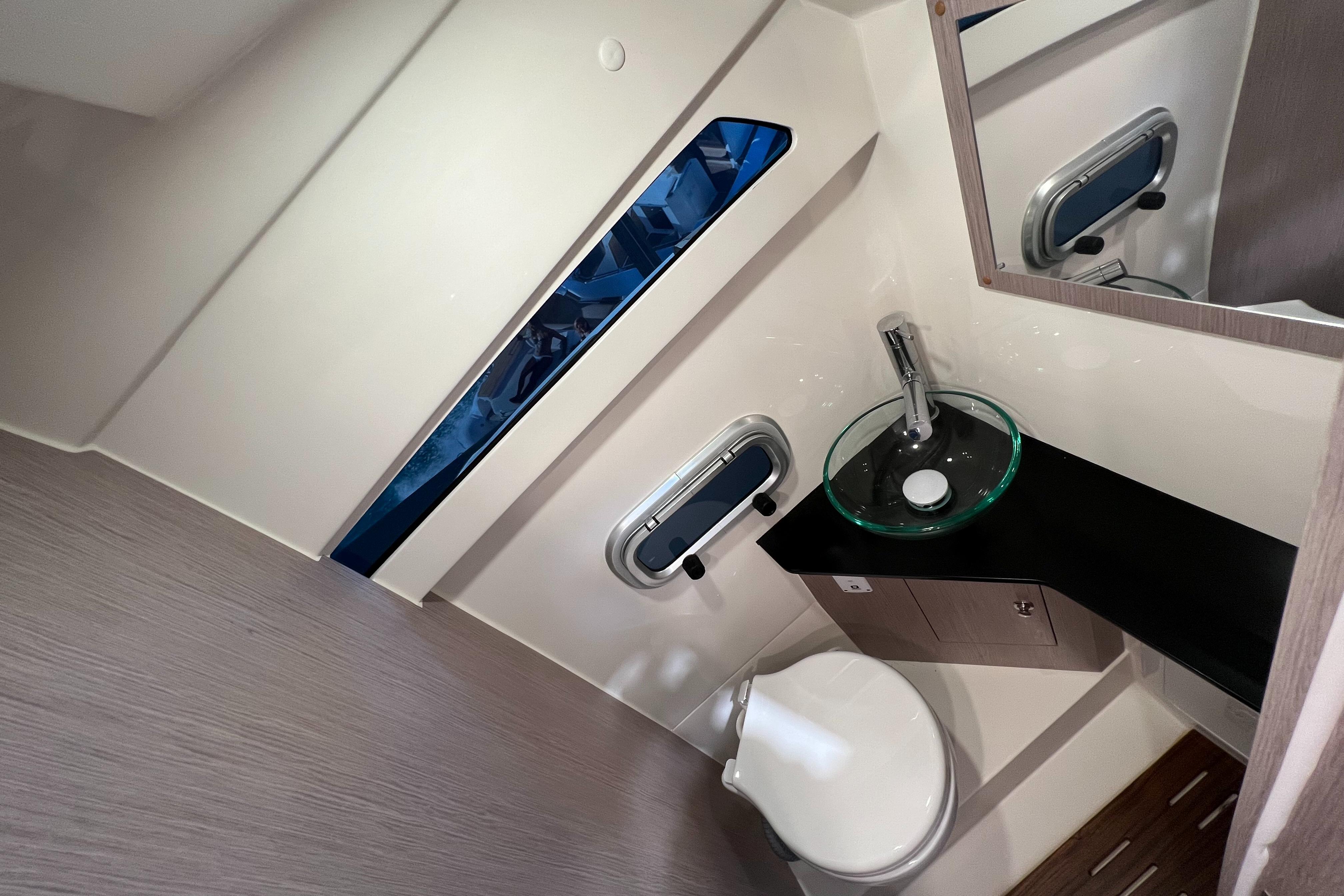 2023 Lomac GranTurismo 12.0 boat bathroom with modern sink and porthole window.