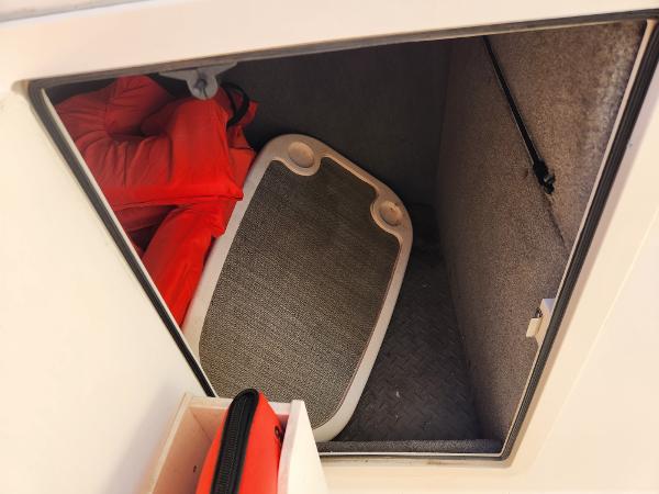 Storage compartment in a 2015 Grady-White Freedom 275 boat with life jackets and a table.