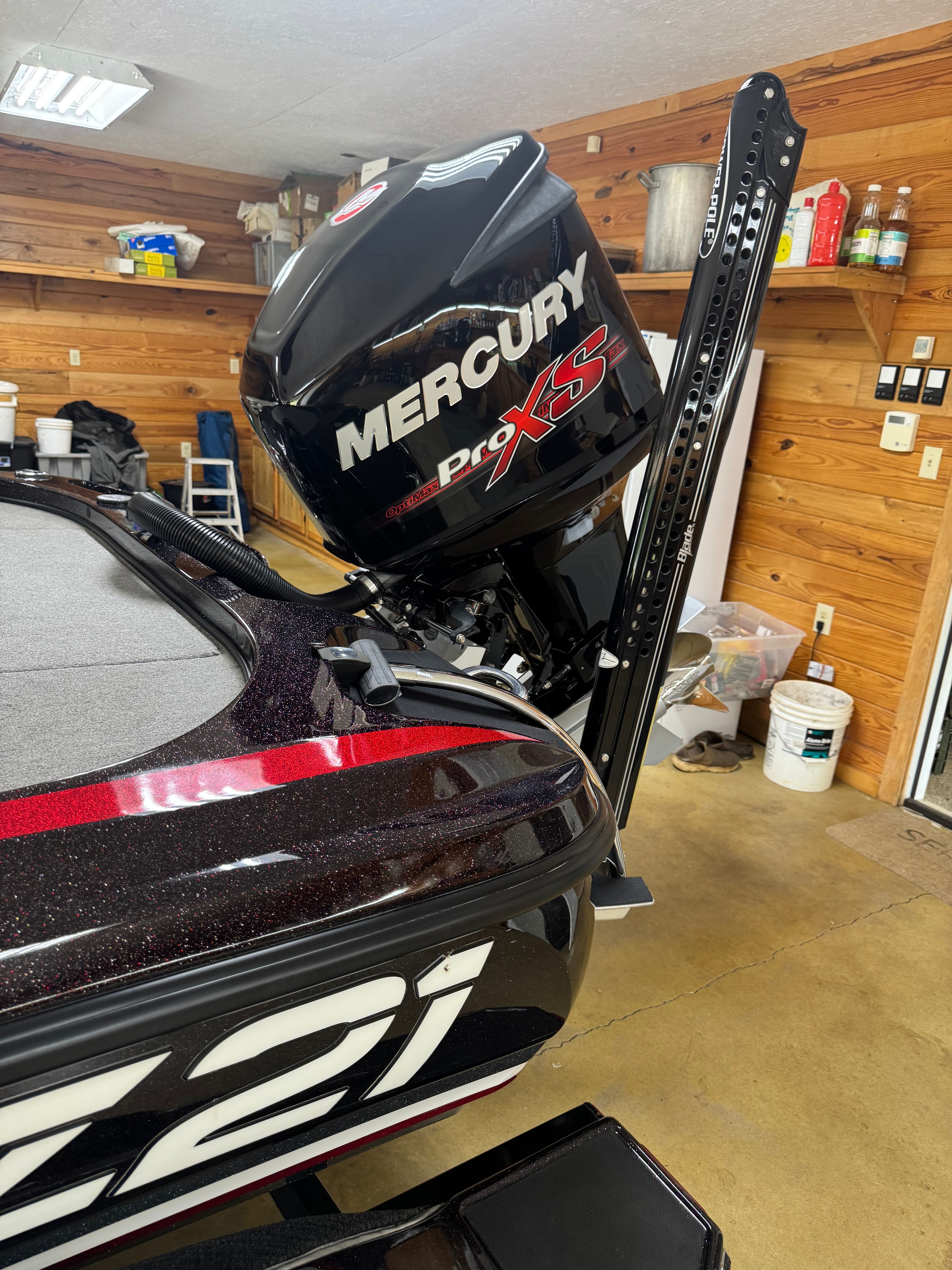 A Nitro Z21 boat with a Mercury Pro XS engine in a garage.