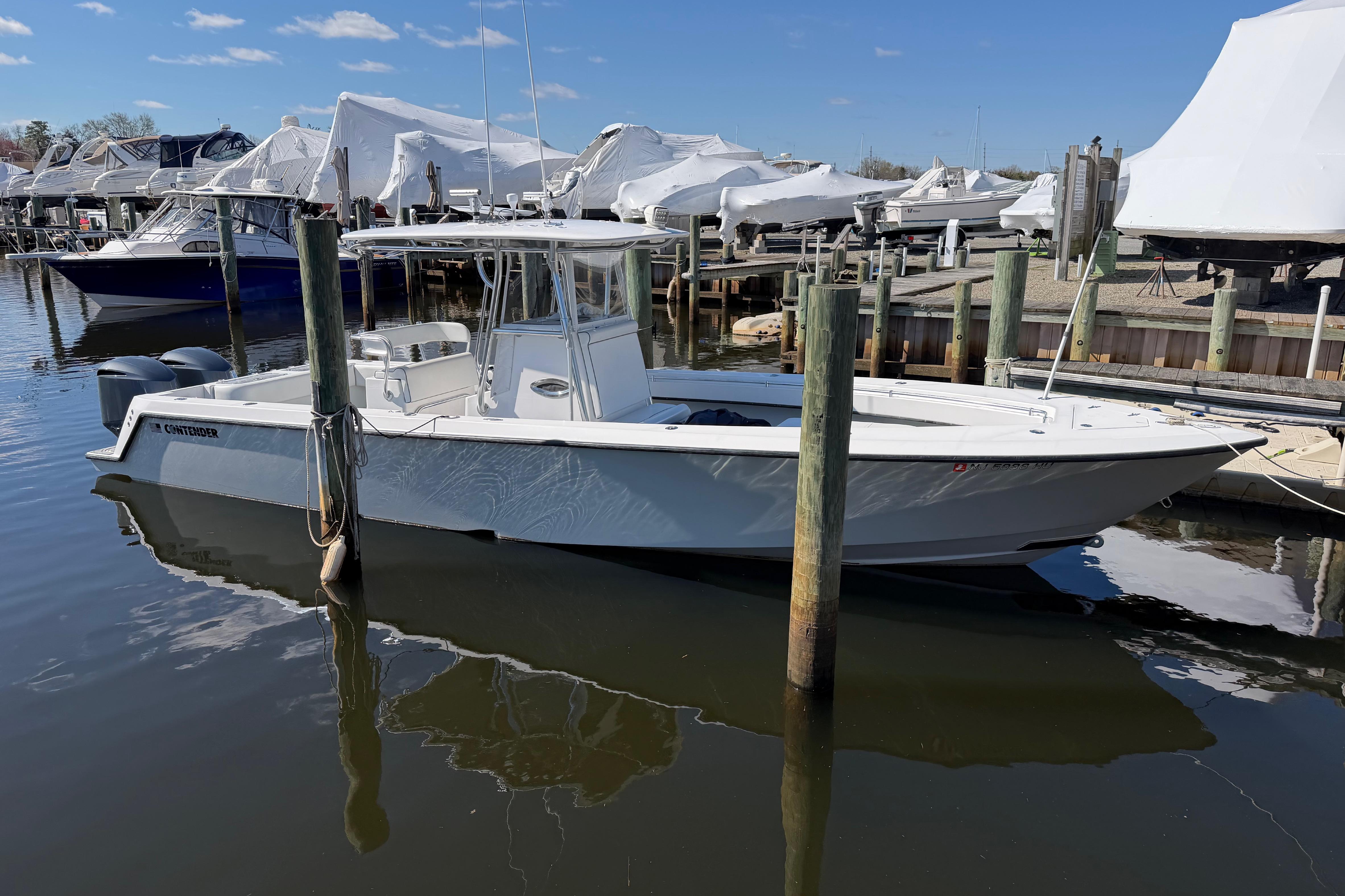 2015 Contender 32 ST boat docked at marina, clear sky, calm water.