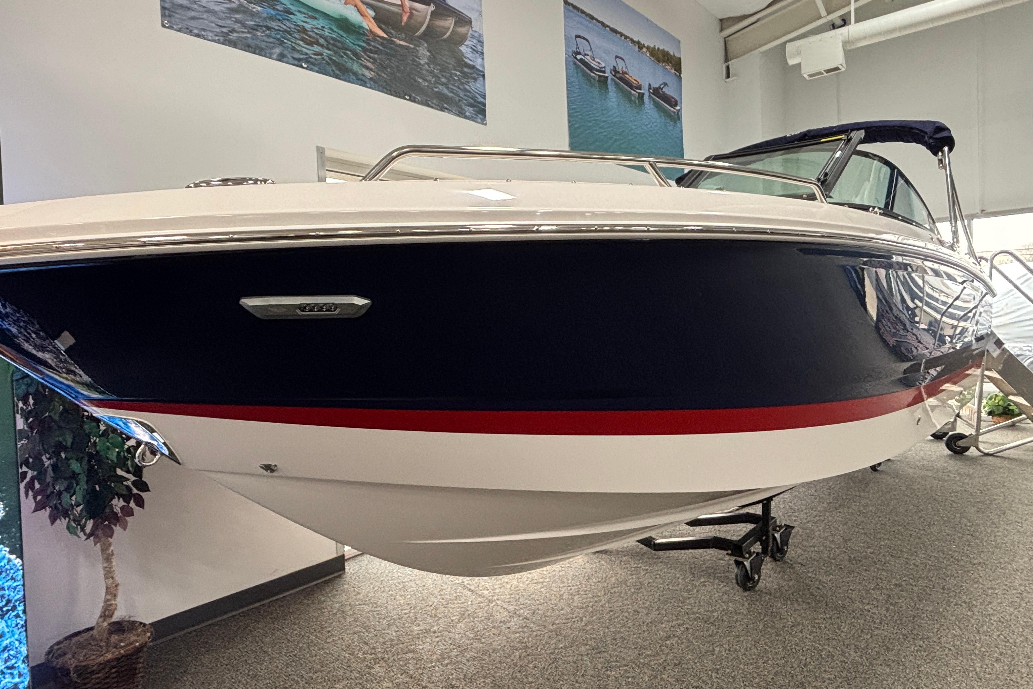 2026 Chaparral SSX 4 boat displayed indoors, featuring sleek design and navy blue exterior.
