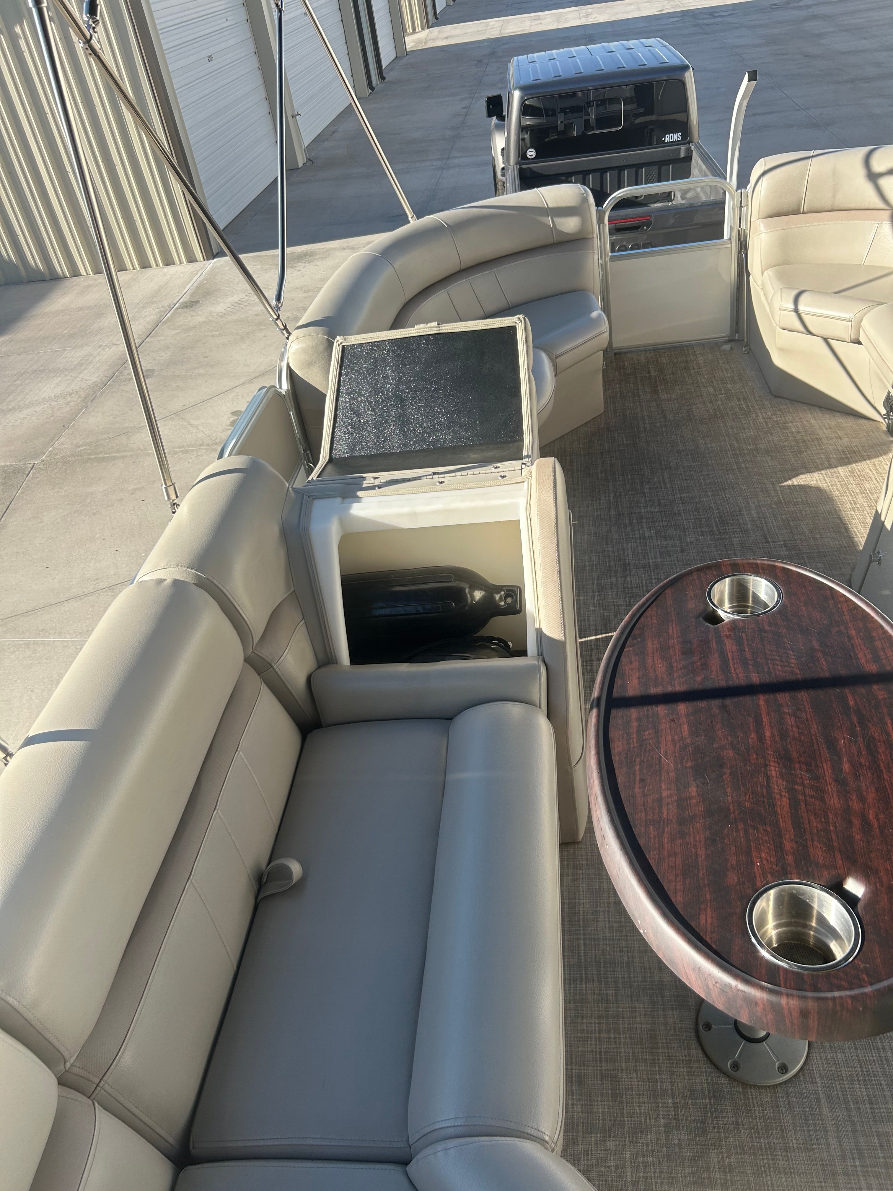 The image shows the interior of a 2018 Berkshire 24RFX CTS pontoon boat with beige leather seating and a wooden table.