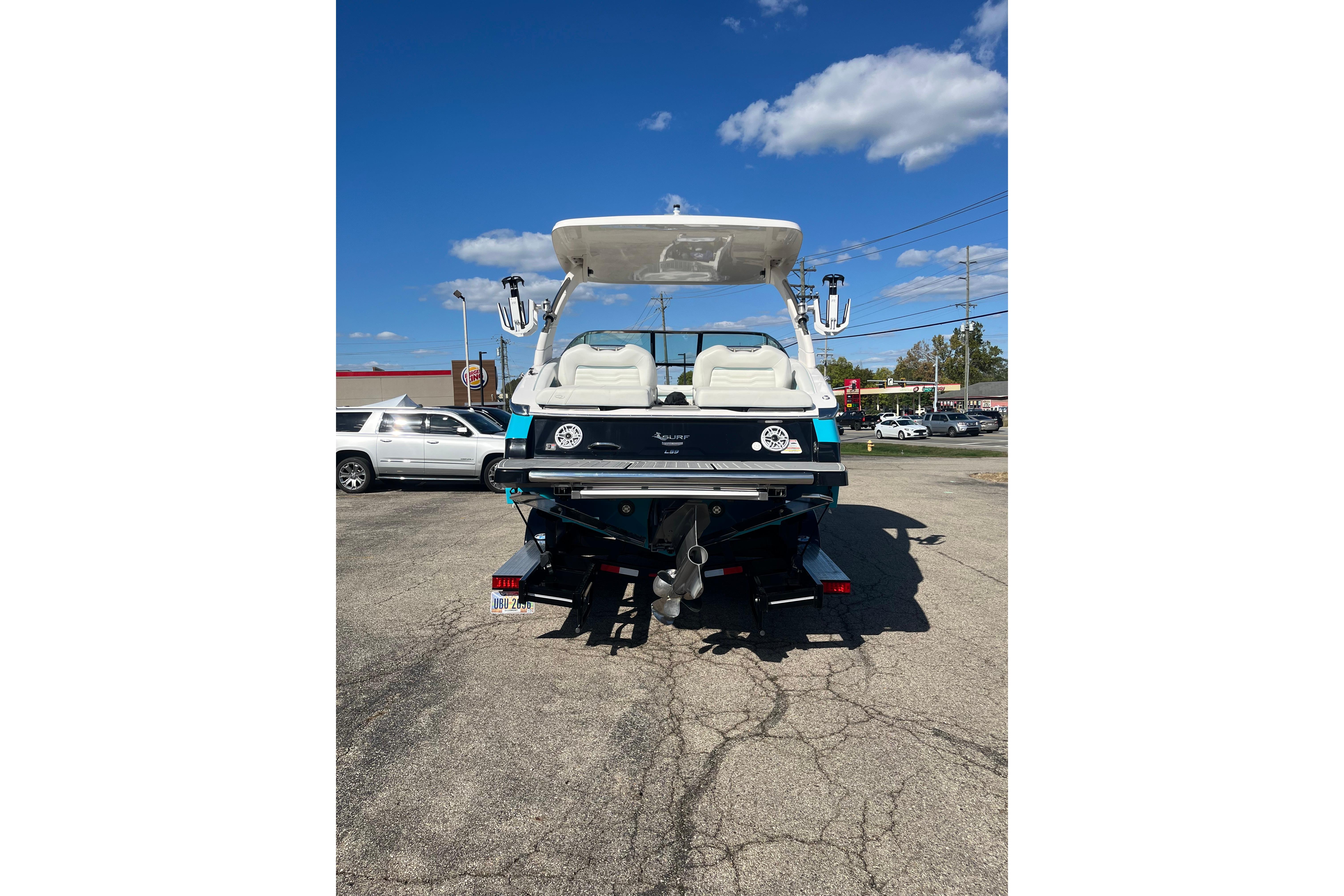 2024 Regal LS9 Surf boat rear view in parking lot under clear blue sky.