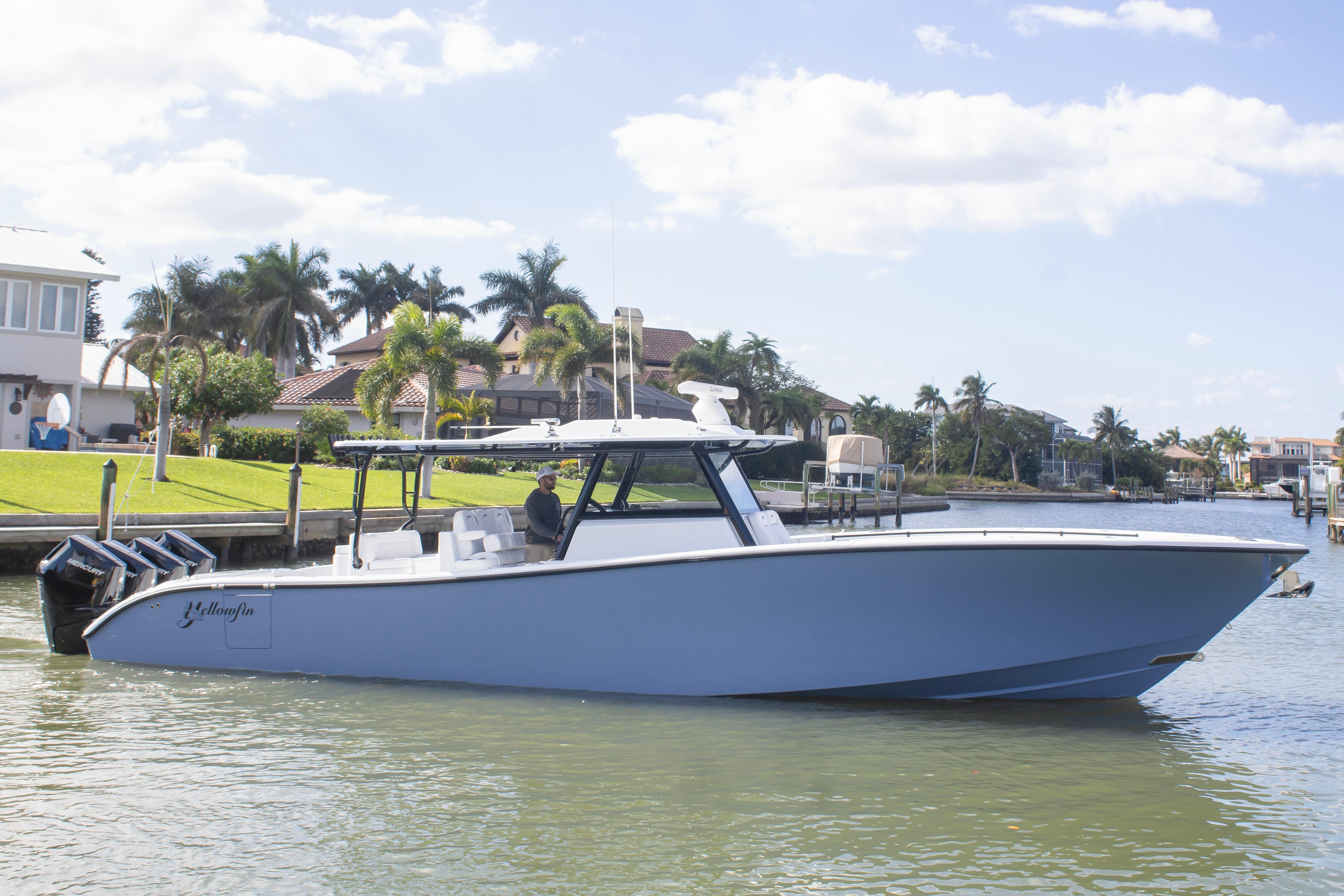 2026 Yellowfin 42 Offshore boat on calm water near luxury homes.