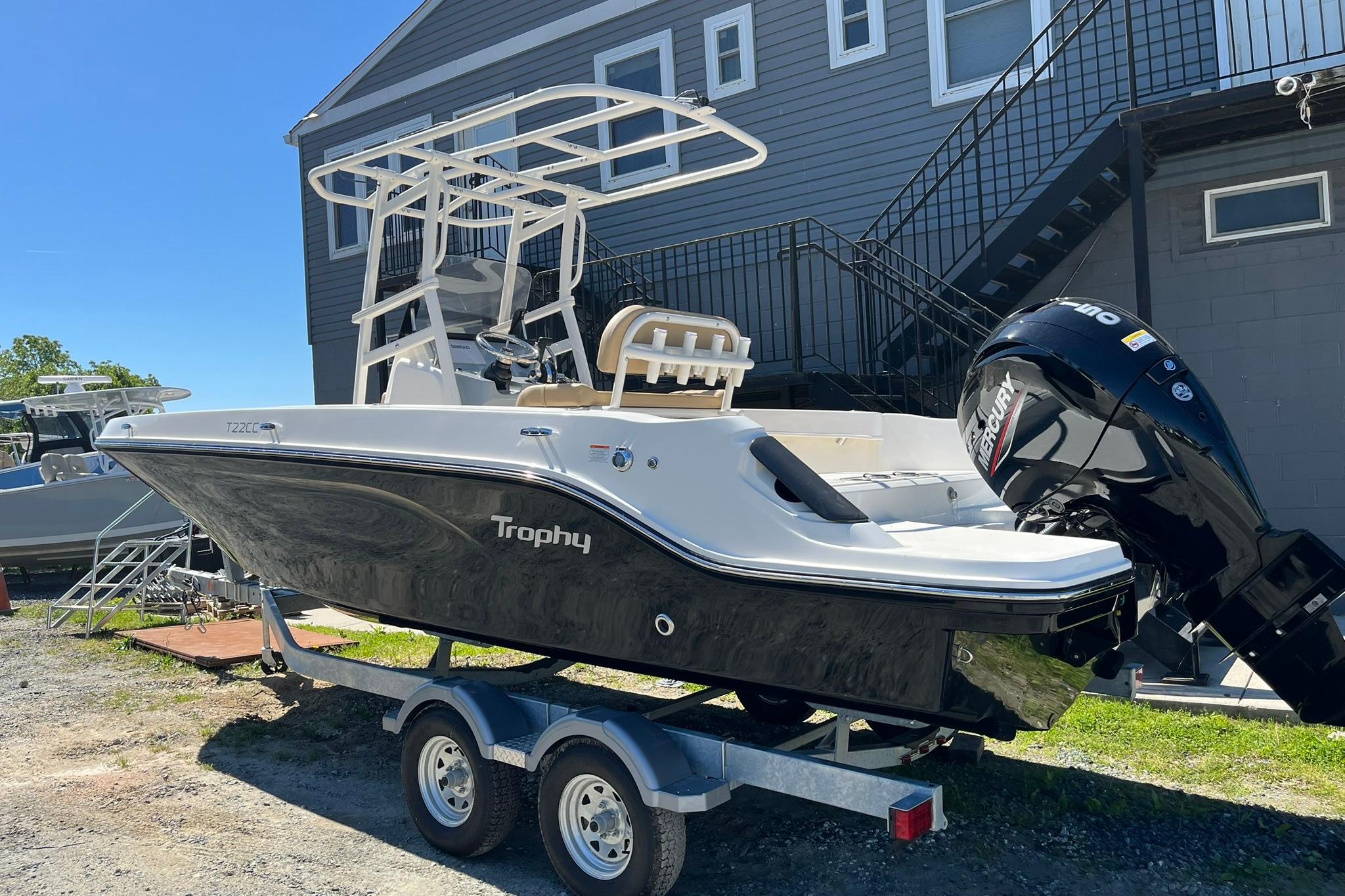 2026 Bayliner Trophy T22CC boat on trailer, parked outdoors near a building.