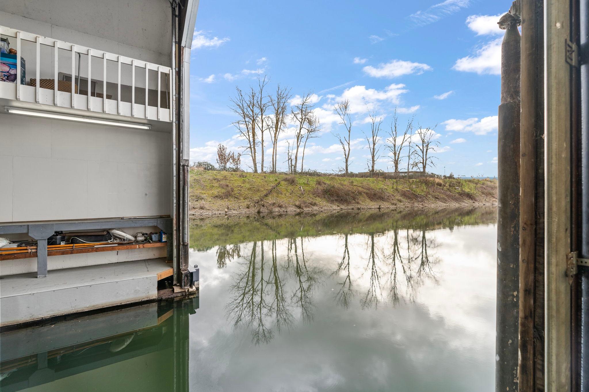 Interior view of a 1976 custom boathouse with serene river reflection.