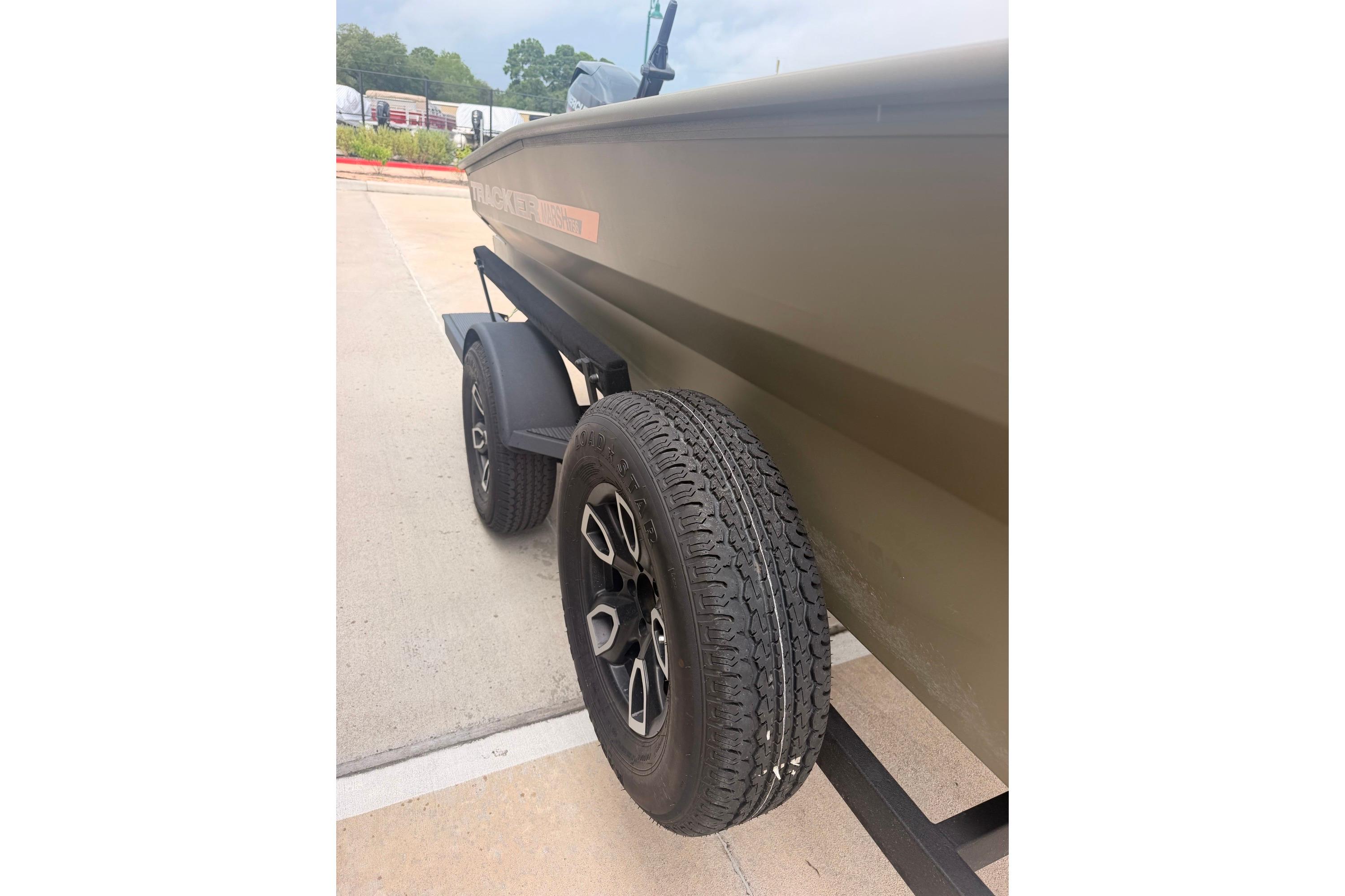 2026 Tracker Grizzly 1756 MARSH boat on trailer, showcasing tire and hull details.