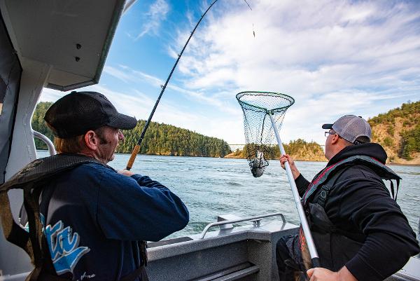 Two men fishing on a 2023 Spartan 220 Maximus Pro boat.