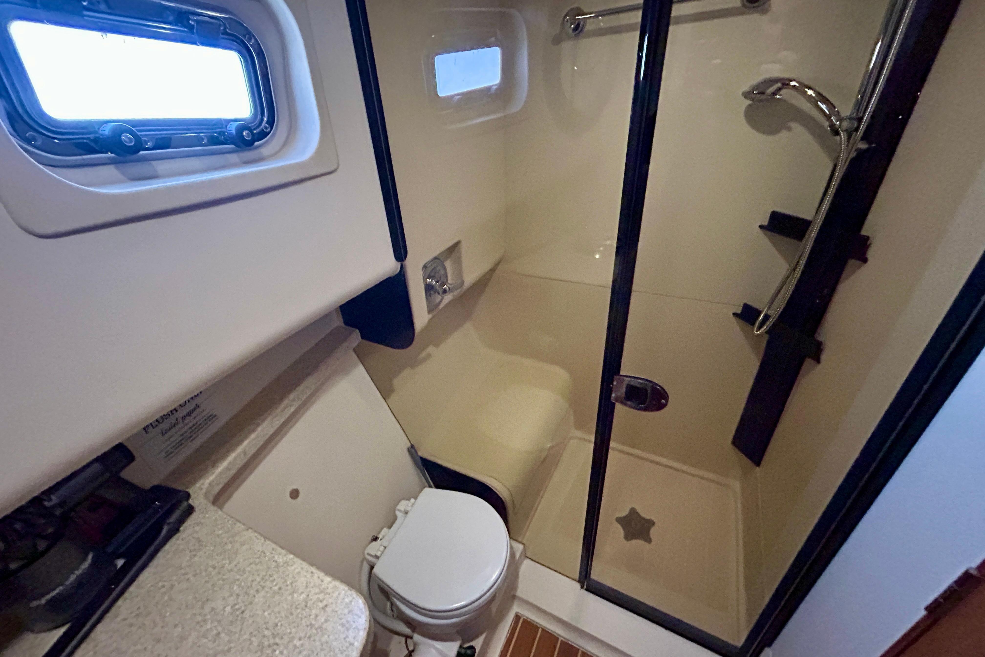 Bathroom interior of 2006 Mainship 34 Trawler with shower and toilet.