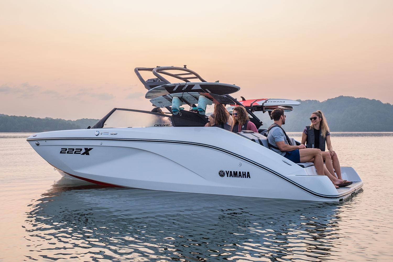 Manufacturer Provided Image: 2026 Yamaha Boats 222XE on serene water at sunset with passengers enjoying the ride.