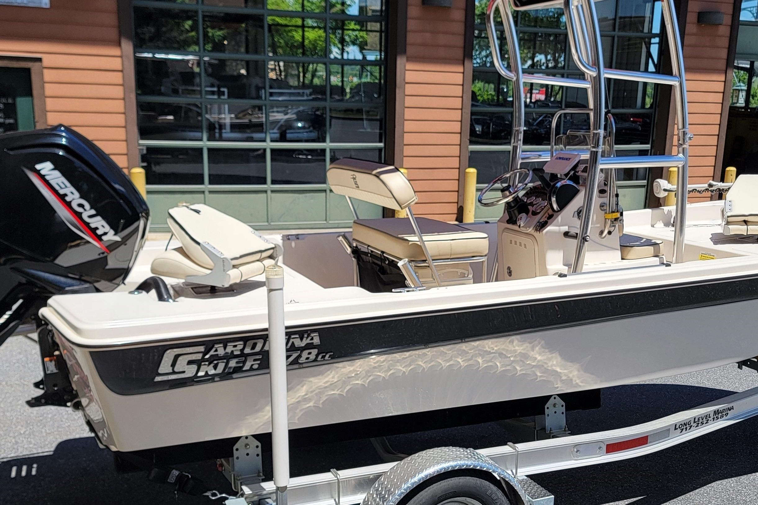 2021 Carolina Skiff 178 JLS boat with Mercury engine on trailer, parked outdoors.