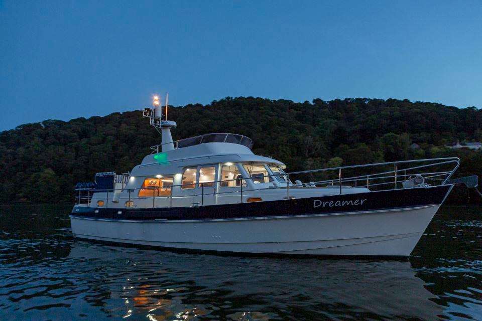 Hardy Commodore 42 yacht, 2002 model, named "Dreamer," illuminated on calm waters at dusk.