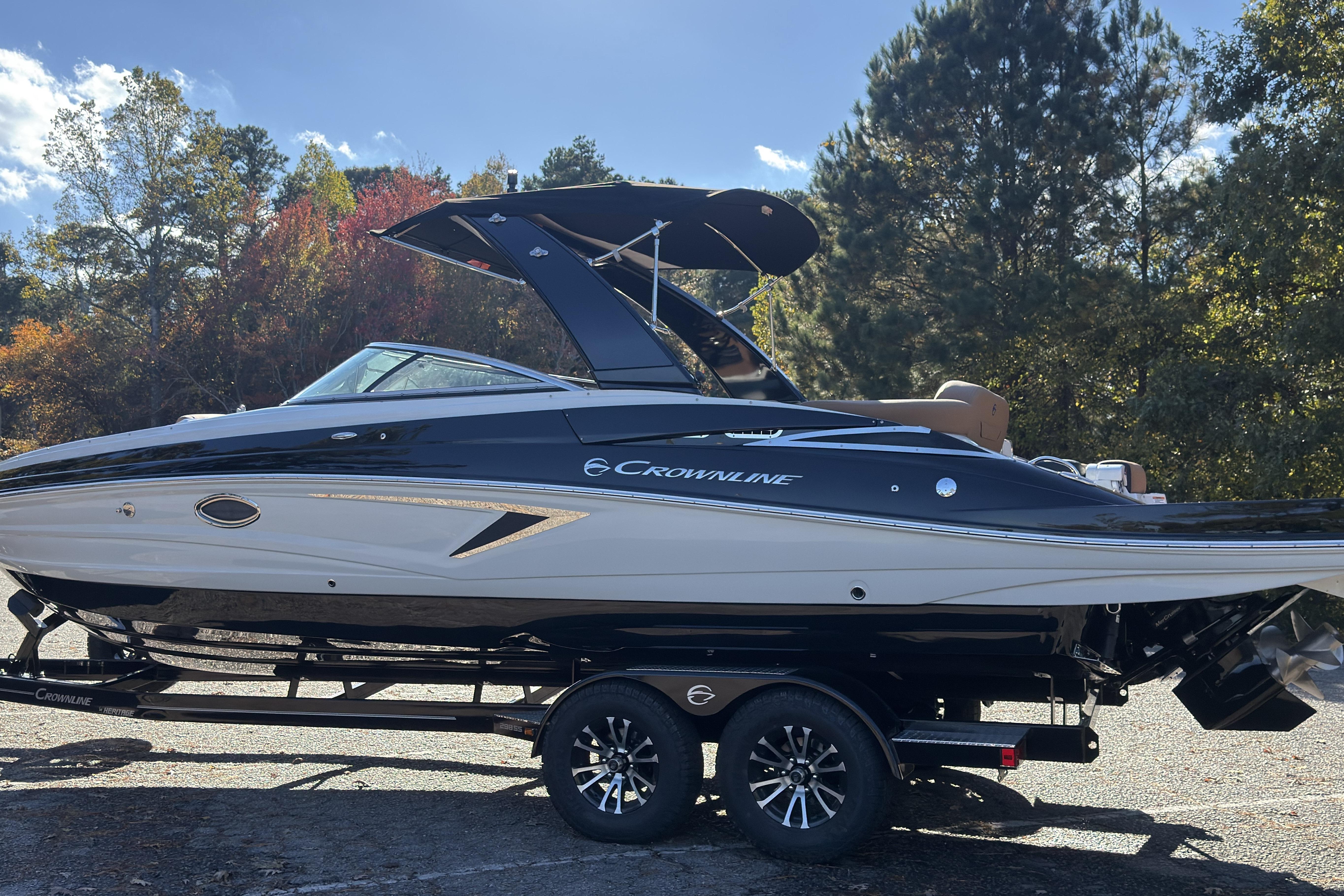 2026 Crownline 298 SS boat on trailer, surrounded by autumn trees.