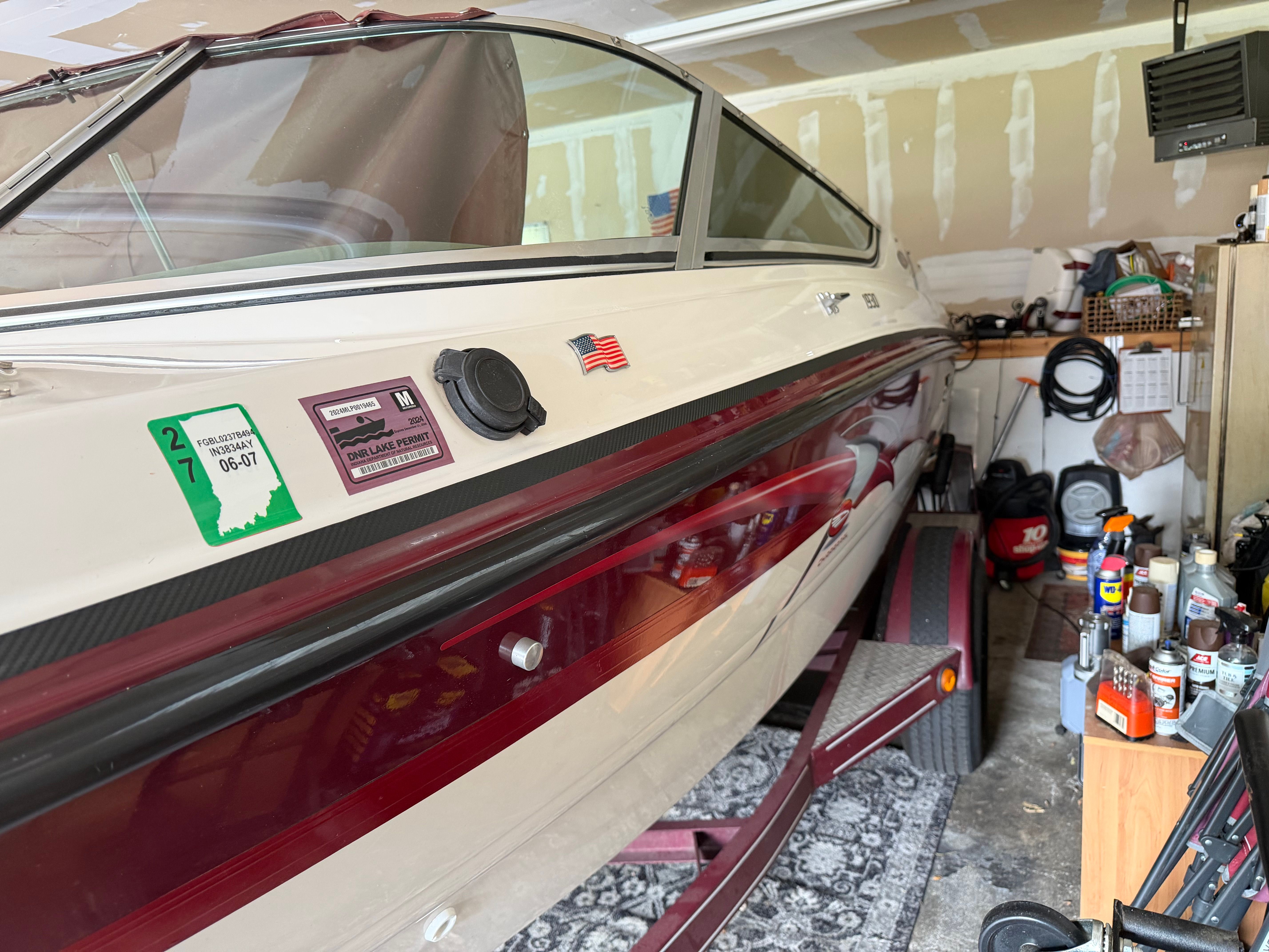A 1994 Chaparral 1930 boat is in a garage. It features a white and red paint scheme.