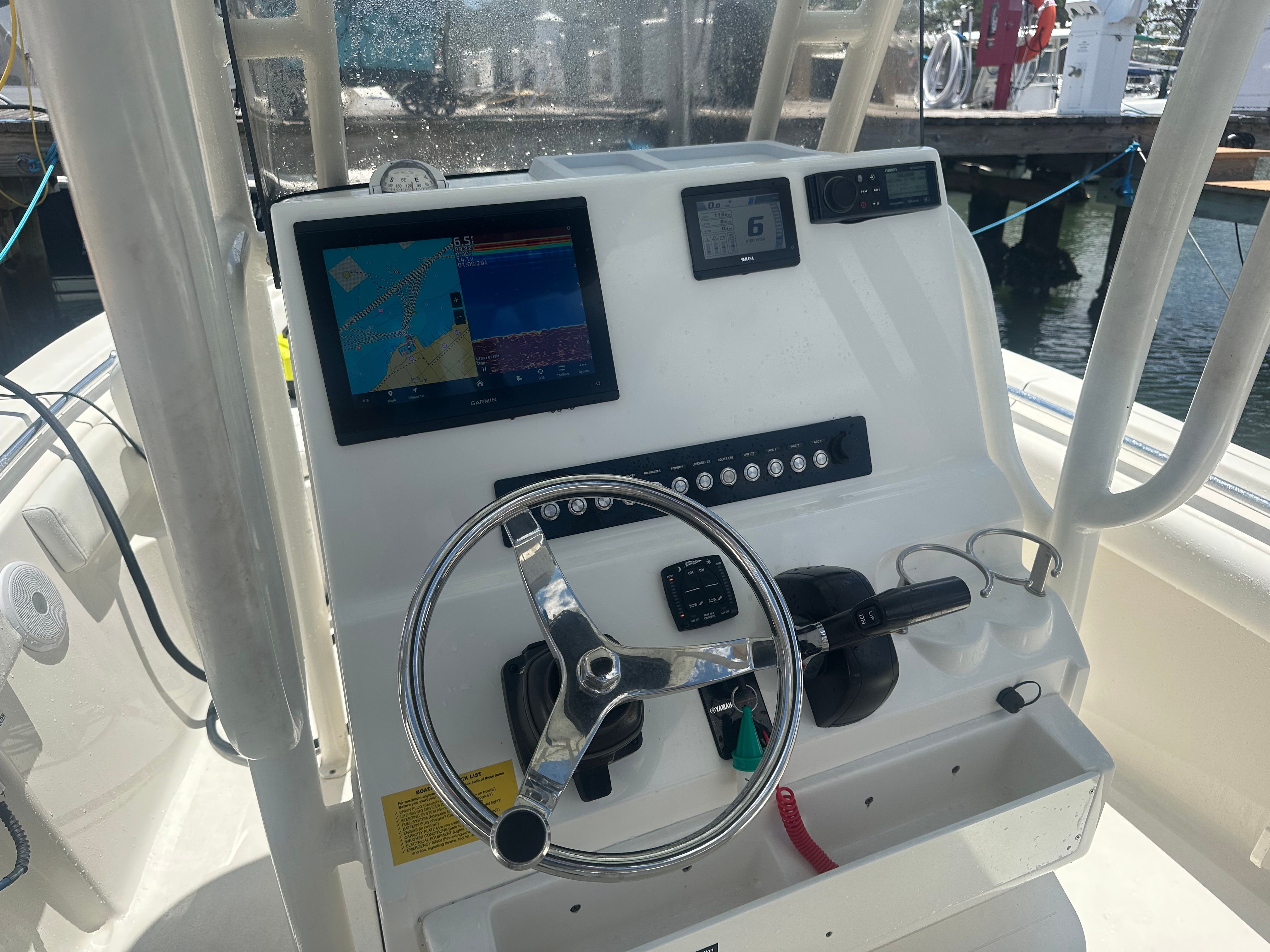 The helm of a boat with a steering wheel and navigation system.