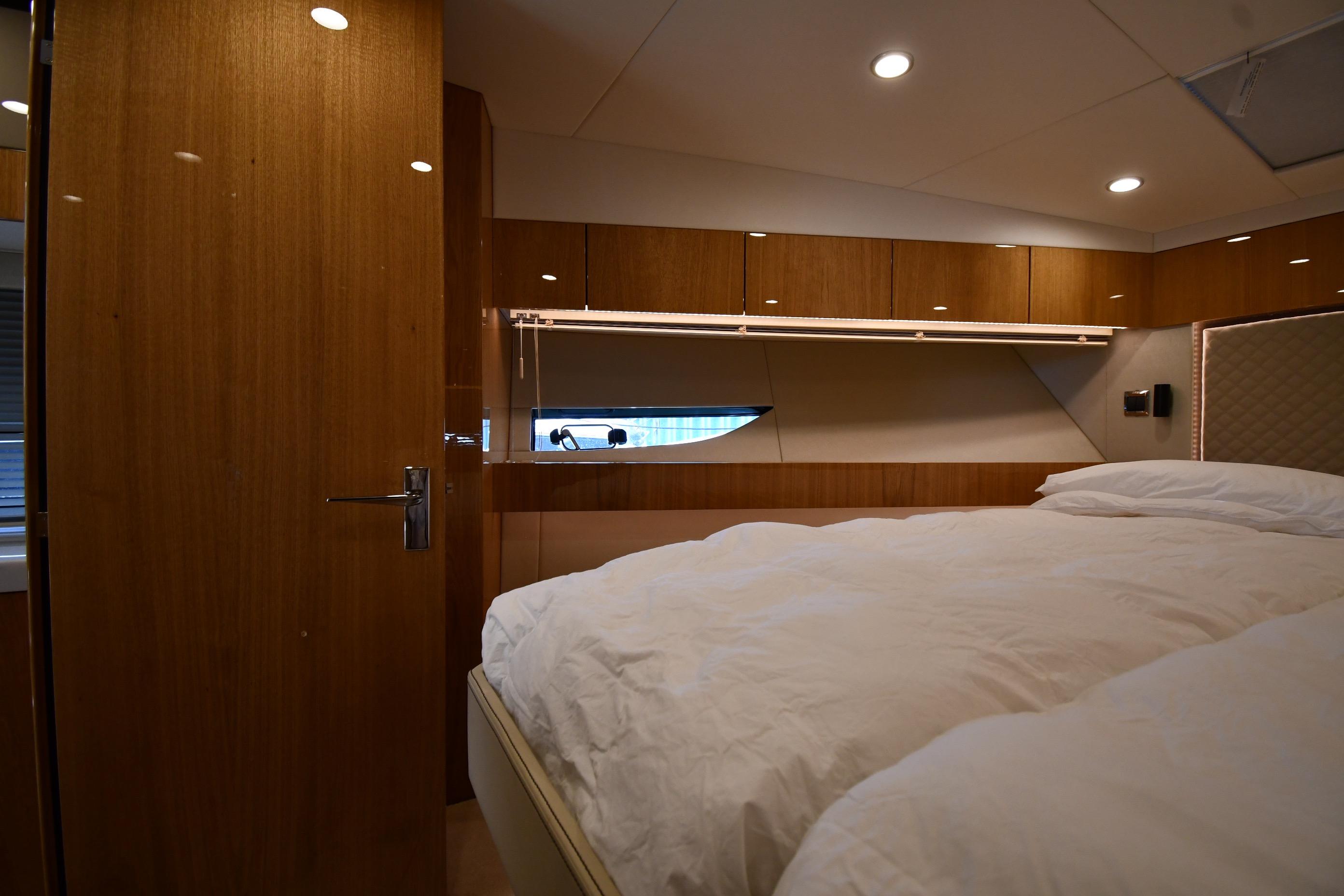Luxurious bedroom interior of 2024 Fairline G50 Targa yacht with wood paneling.