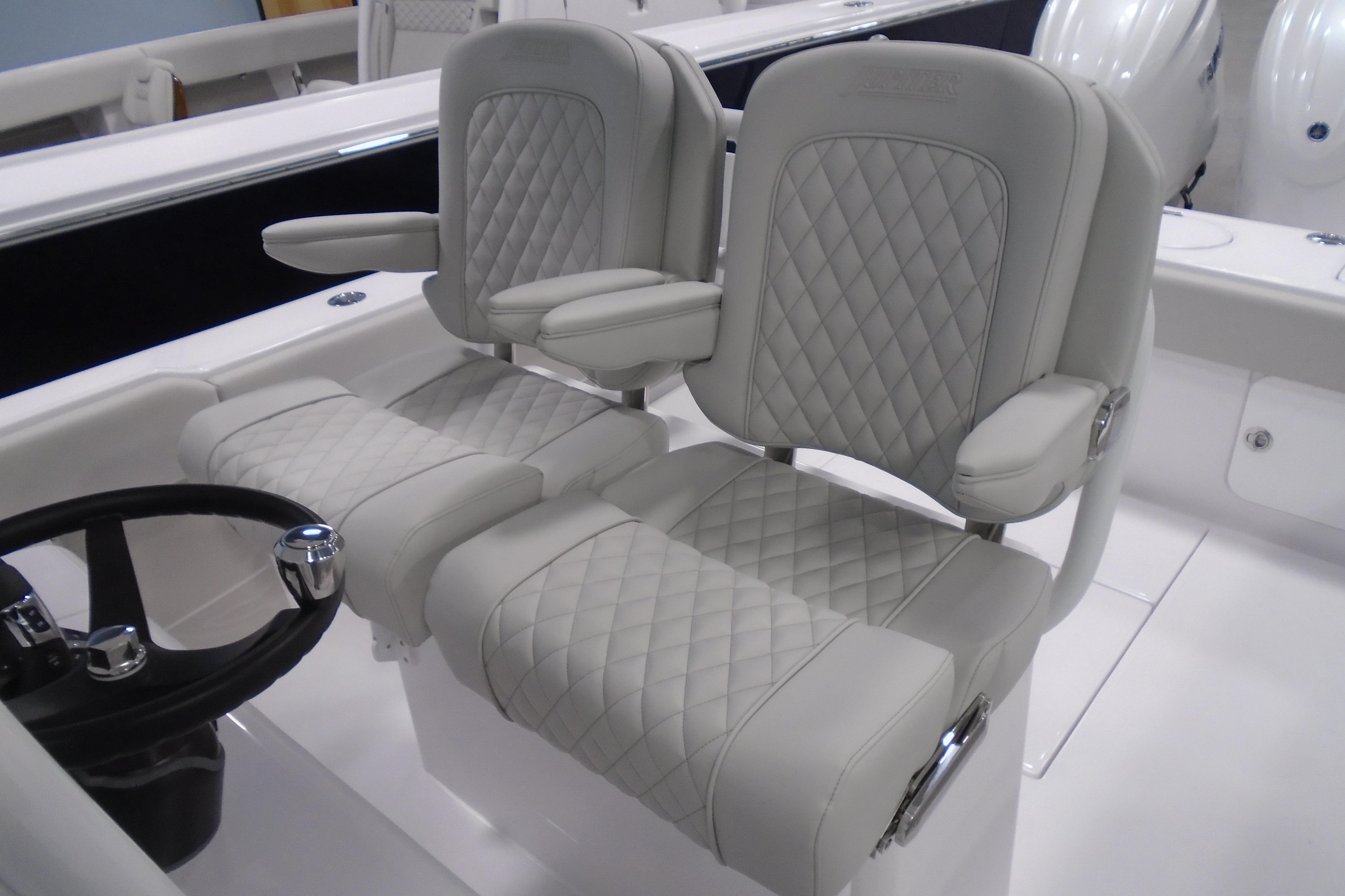 Luxurious seating on 2026 Jupiter 26 boat with quilted upholstery and armrests.