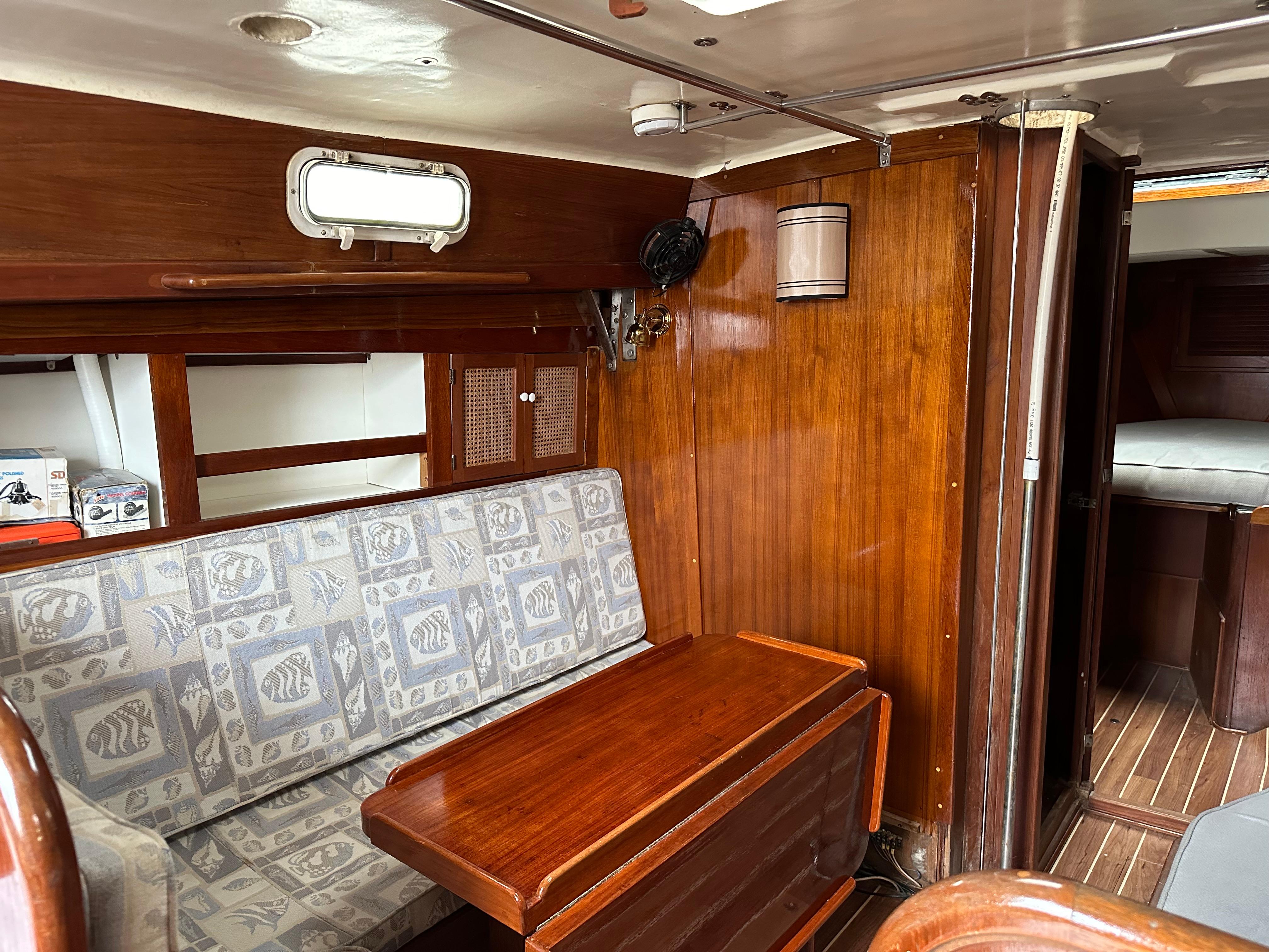 1981 Tartan 37 sloop interior with wood paneling and patterned seating.