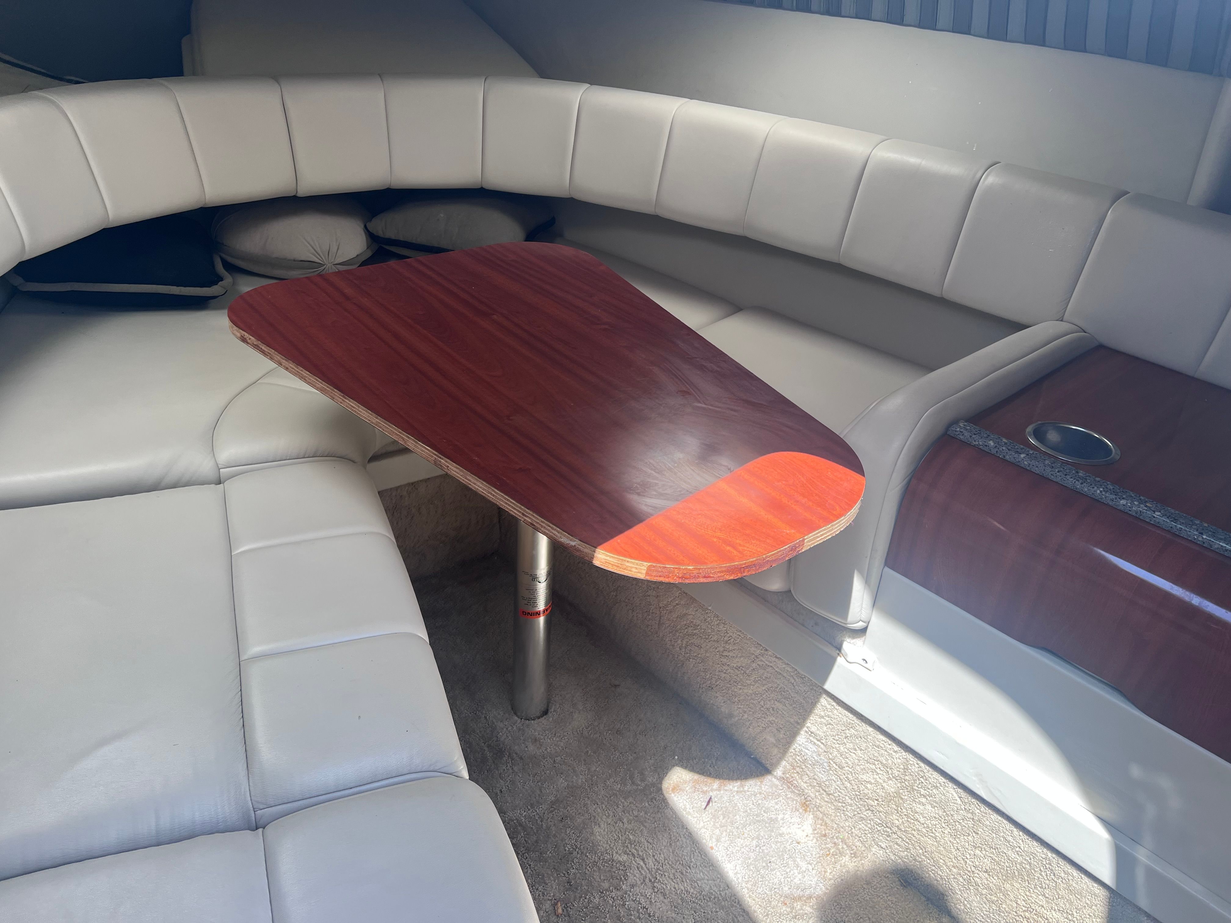 2006 Formula 260 Sun Sport interior with leather seating and wooden table.