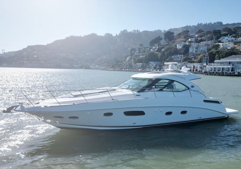 2010 Sea Ray 470 Sundancer on calm waters with coastal backdrop.