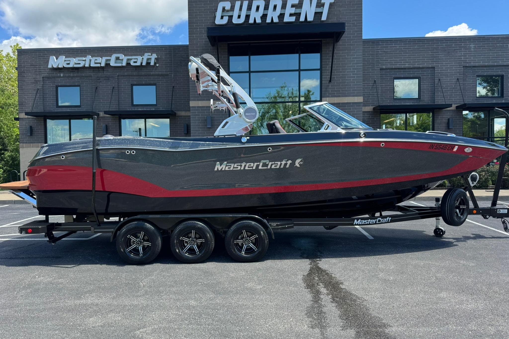2021 MasterCraft X26 boat on trailer outside dealership, showcasing sleek design and modern features.
