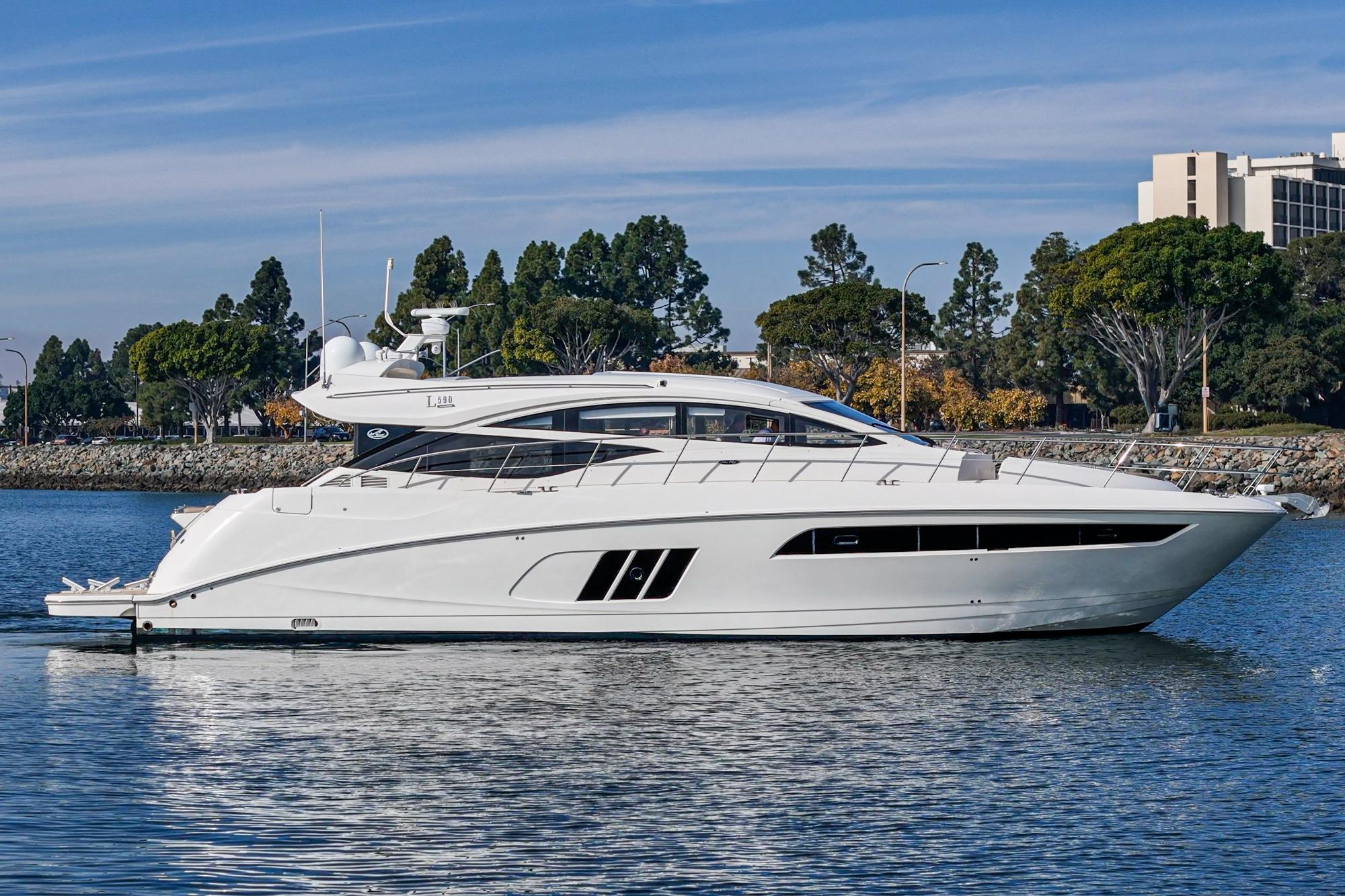2016 Sea Ray L590 yacht on calm water, surrounded by trees and buildings.