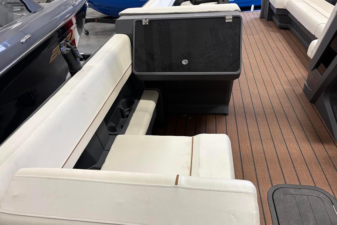 2023 Manitou EXPLORE 26 SHP 575 boat interior with white seating and wood flooring.