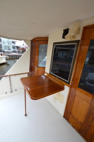 A sleek wooden table on the deck of a 1980 Hatteras 53 Yacht Fisherman.