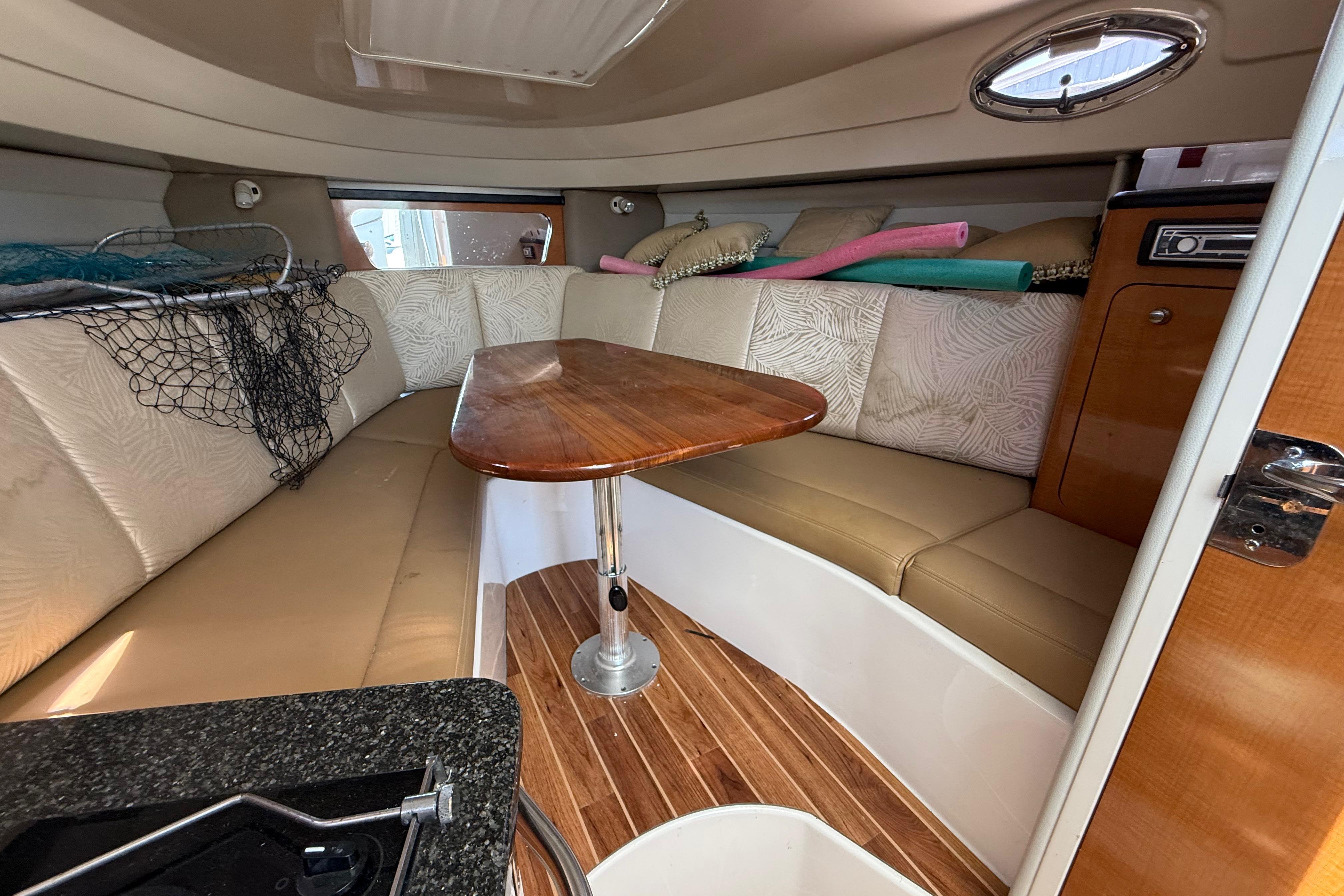 Interior of 2007 Robalo R305 Walkaround boat with seating and wooden table.