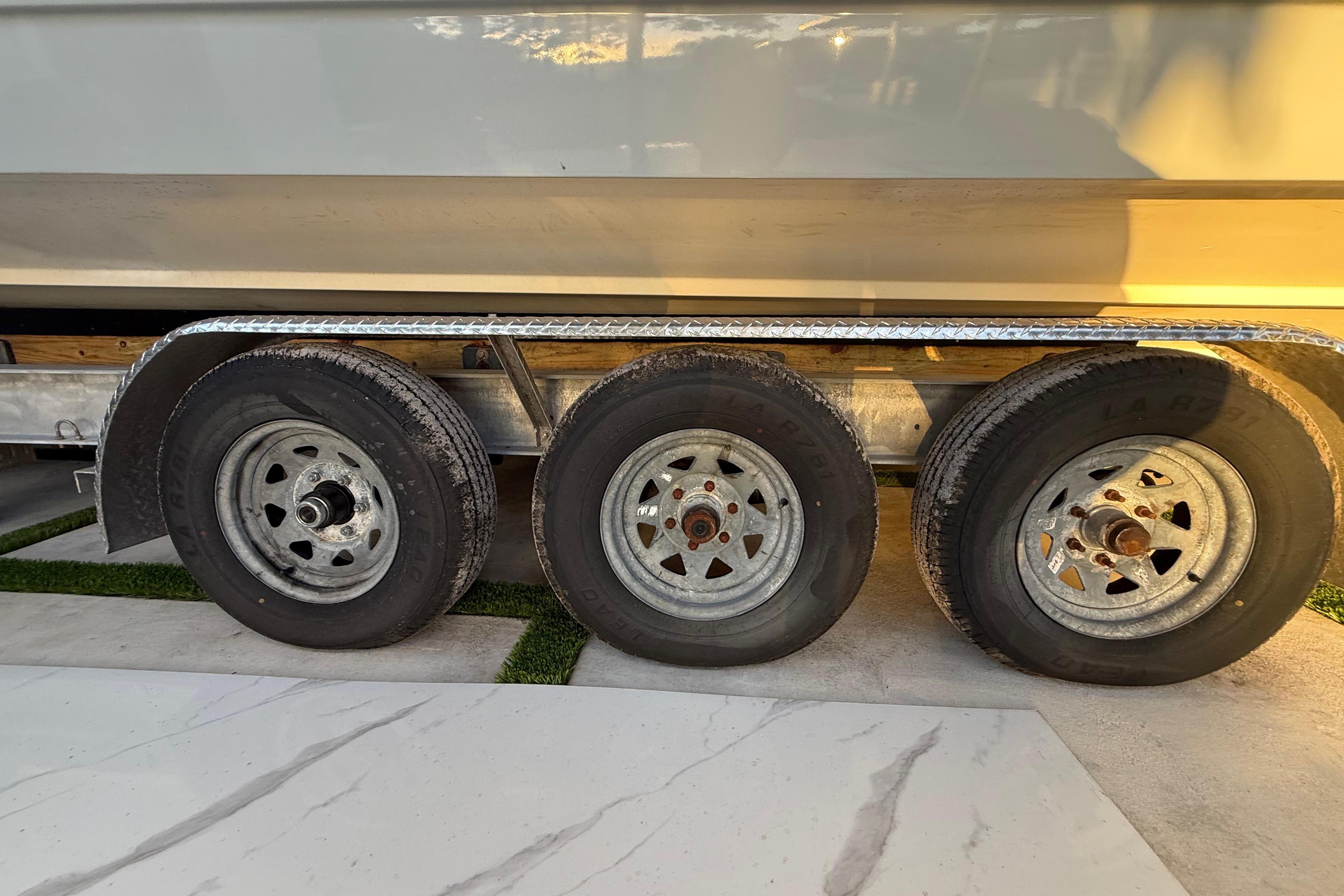 Trailer wheels of a 2005 Formula 330 Sun Sport boat in sunlight.