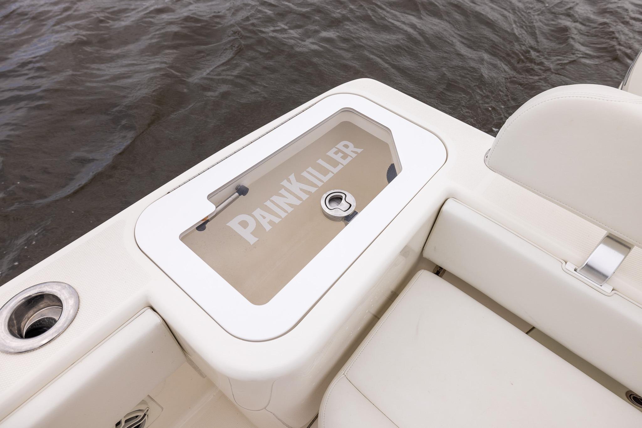 2019 SeaVee 322Z boat with "Painkiller" label on storage compartment, near water.