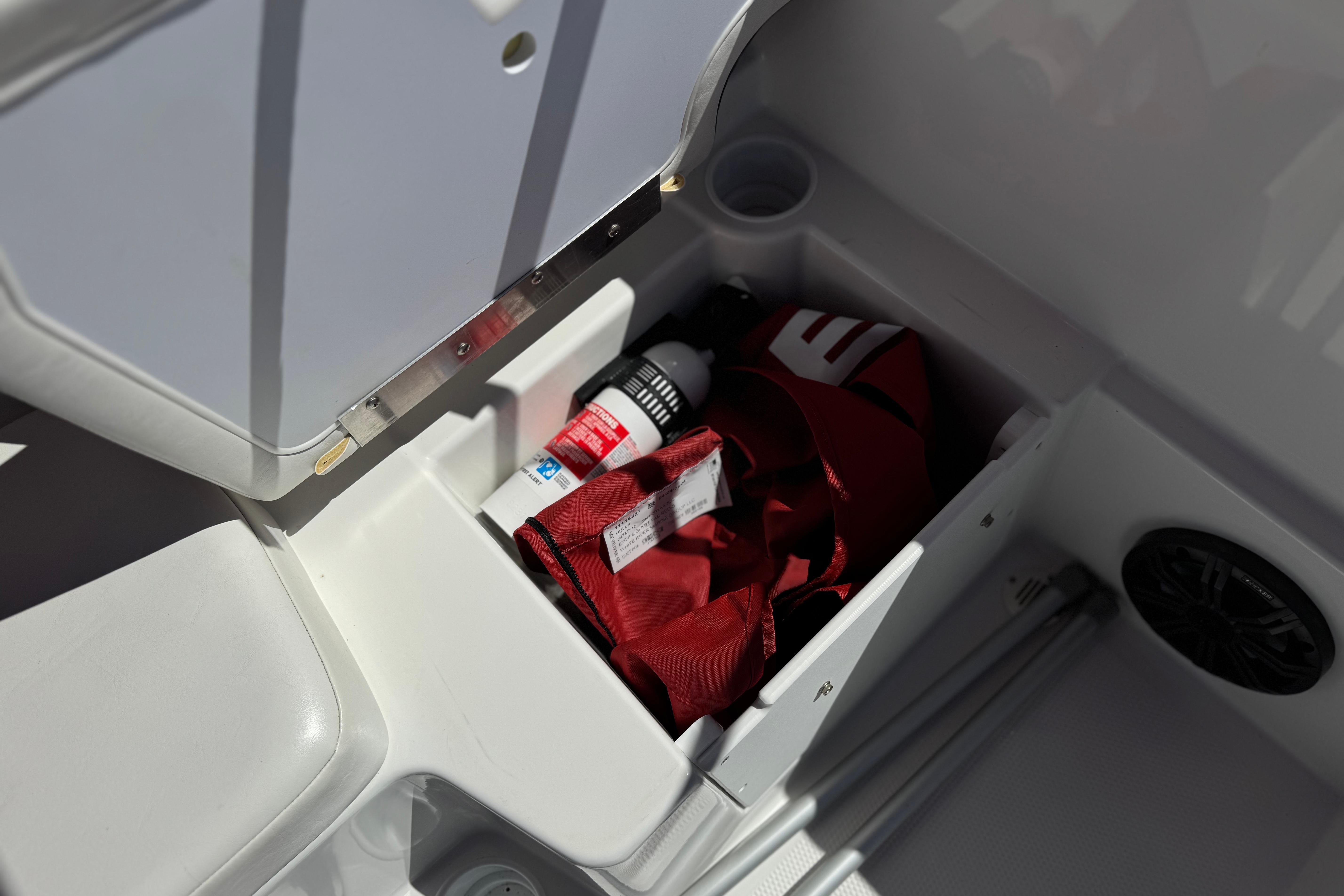 Storage compartment in 2024 Tahoe T16 boat with gear and accessories.