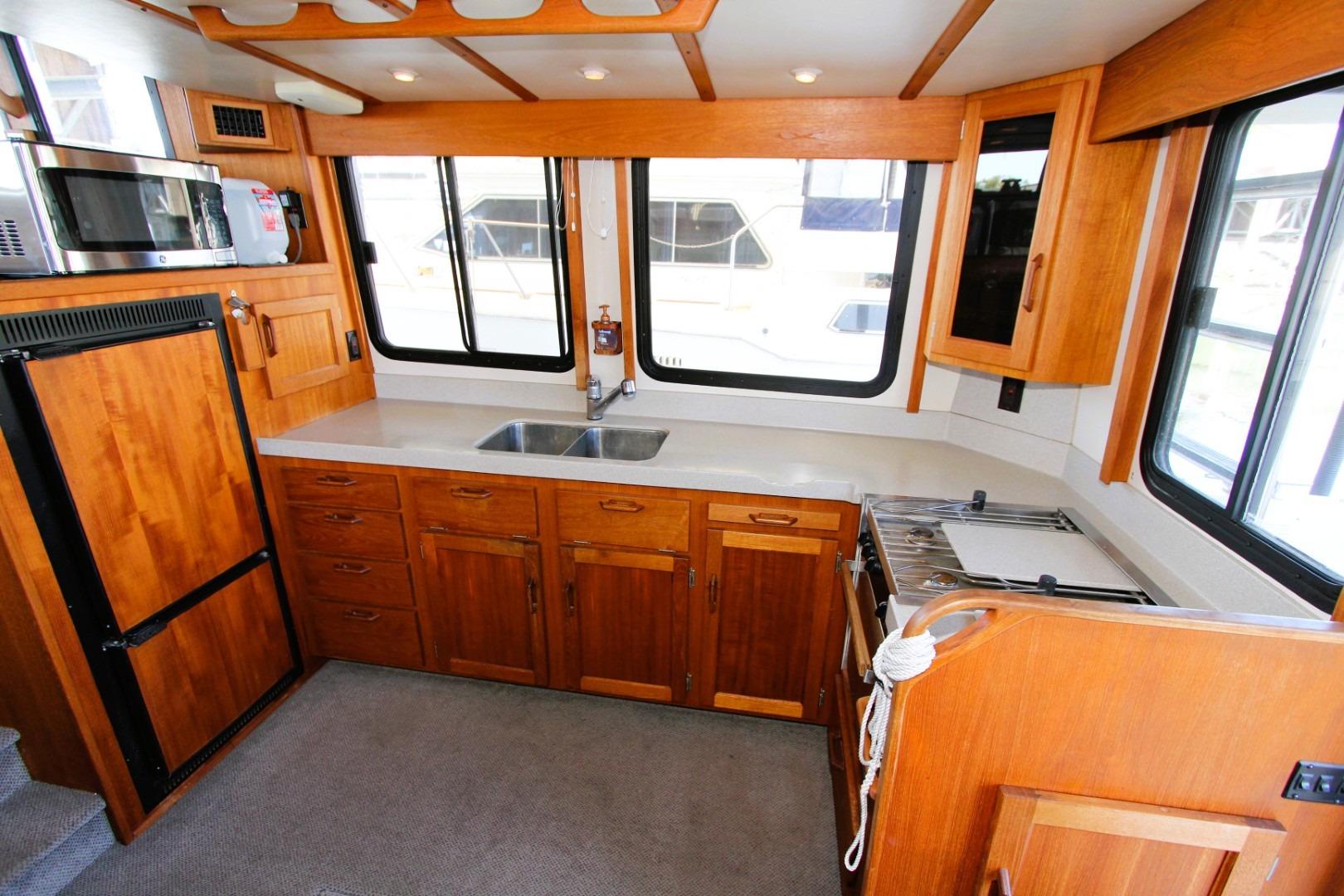 Interior of 2002 Nordic Tug 37, featuring a well-equipped wooden kitchen with modern appliances.