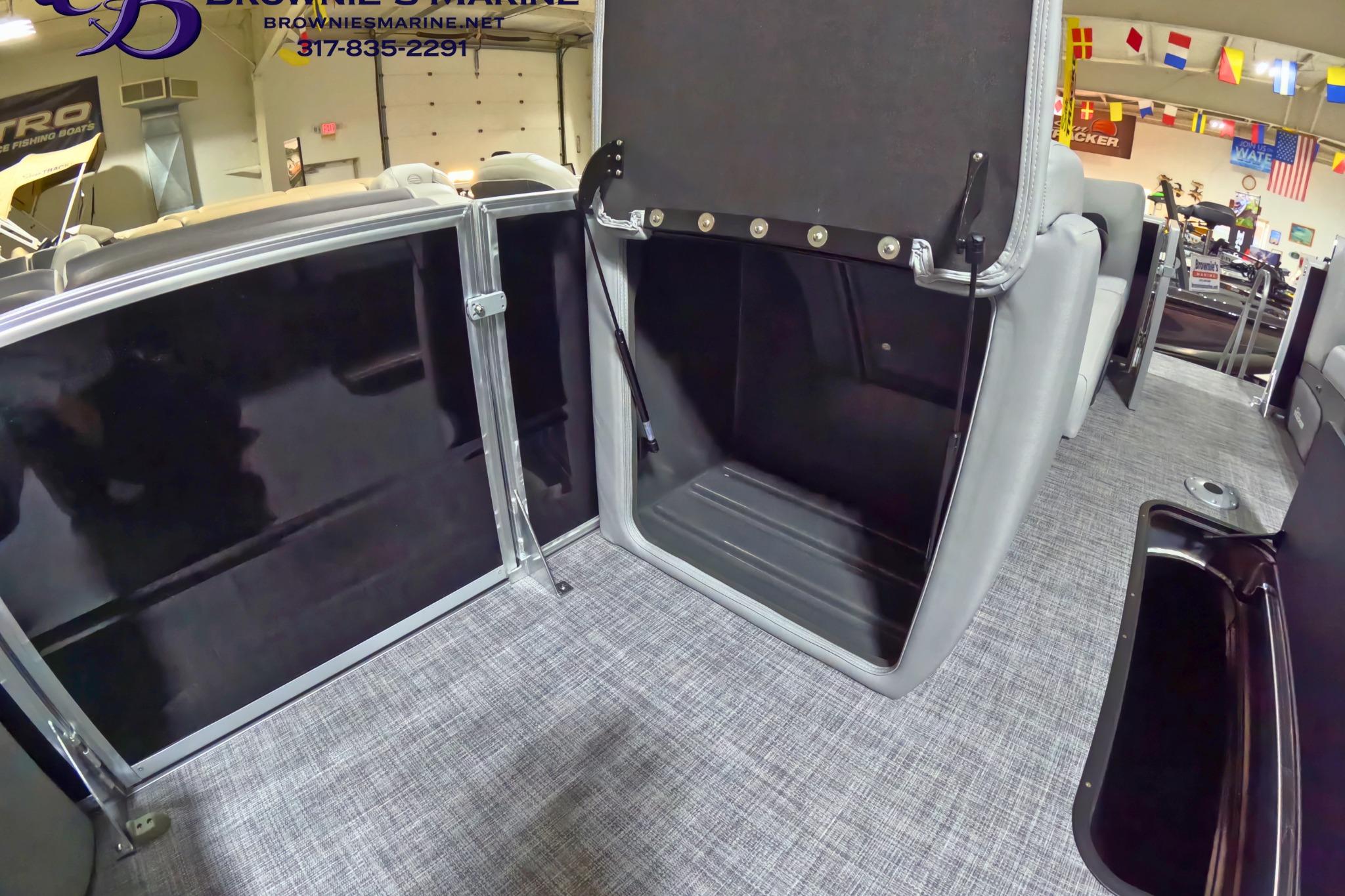 2026 Sun Tracker Party Barge 24 XP3 interior storage compartment with open seat and carpeted floor.