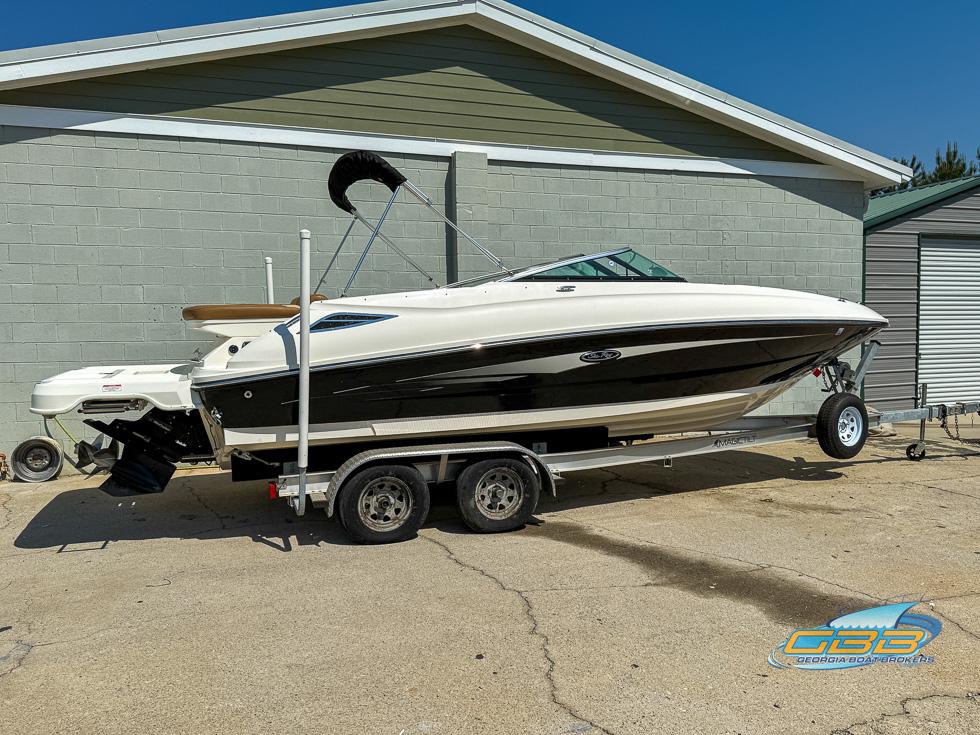 2015 Sea Ray 240 Sundeck boat on trailer, parked outdoors.