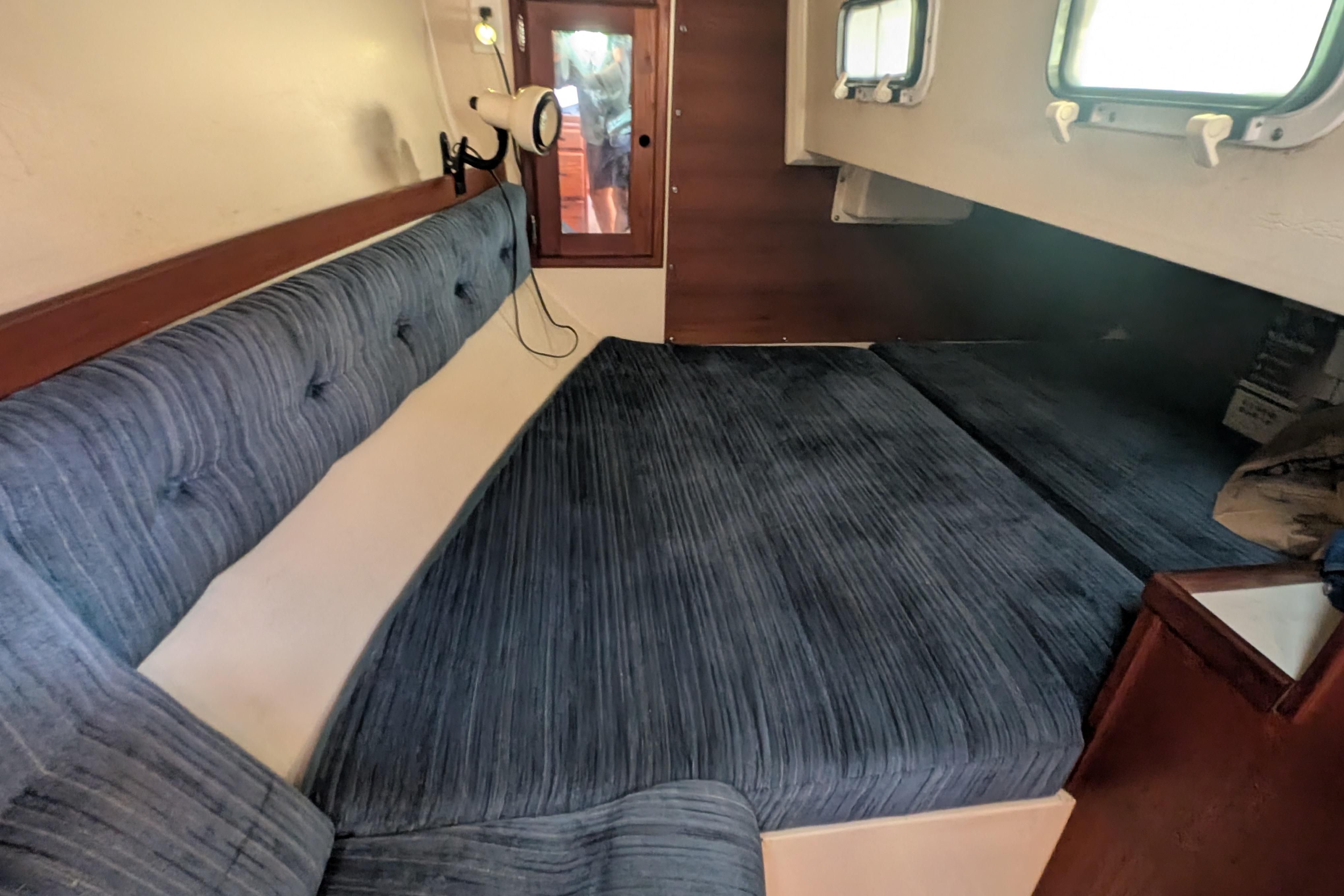Interior cabin of a 1989 Catalina 34 sailboat with blue upholstery and wooden accents.